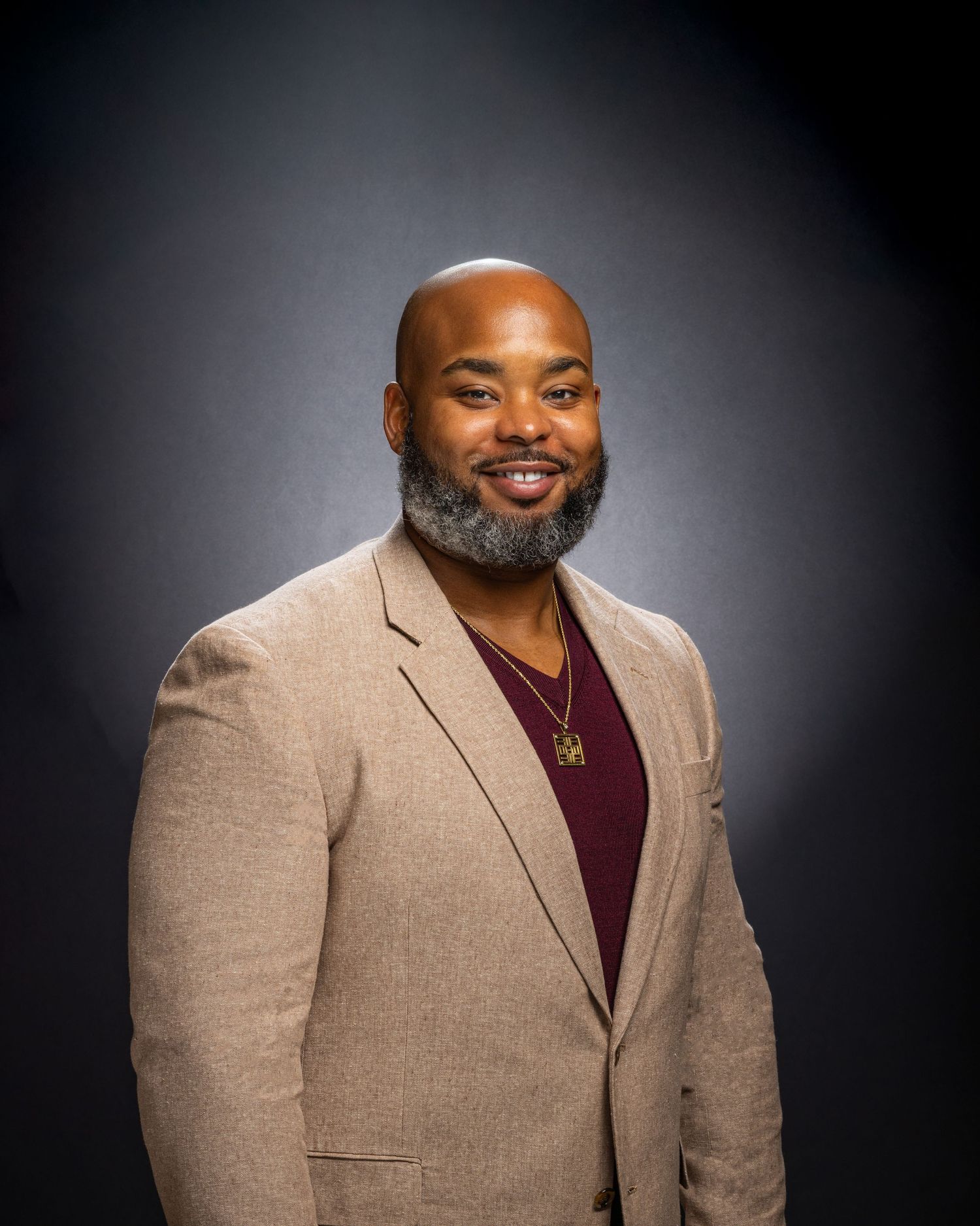 Studio headshots featuring someone in a tan blazer and burgundy shirt with dramatic lighting.