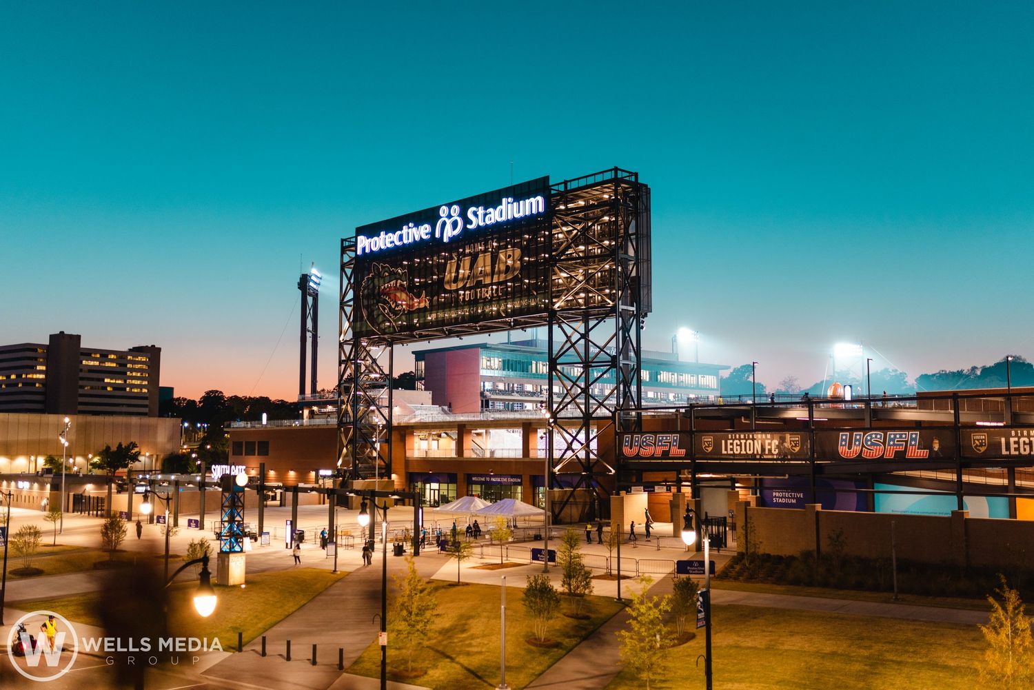 Illuminated Pandoski stadium sign against a twilight sky in an urban setting.