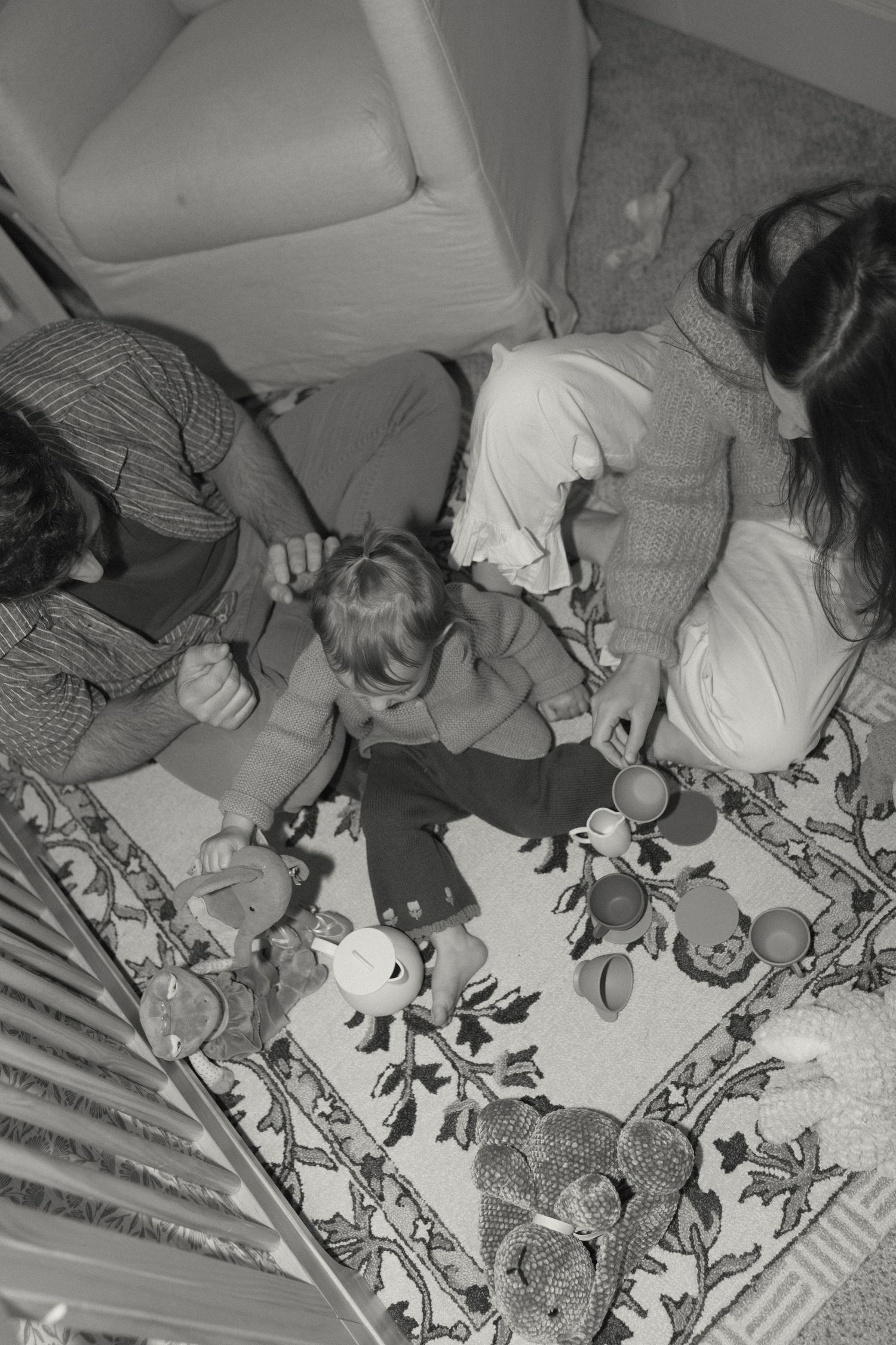 Overhead view of scattered toys and stuffed animals arranged on a light colored surface.