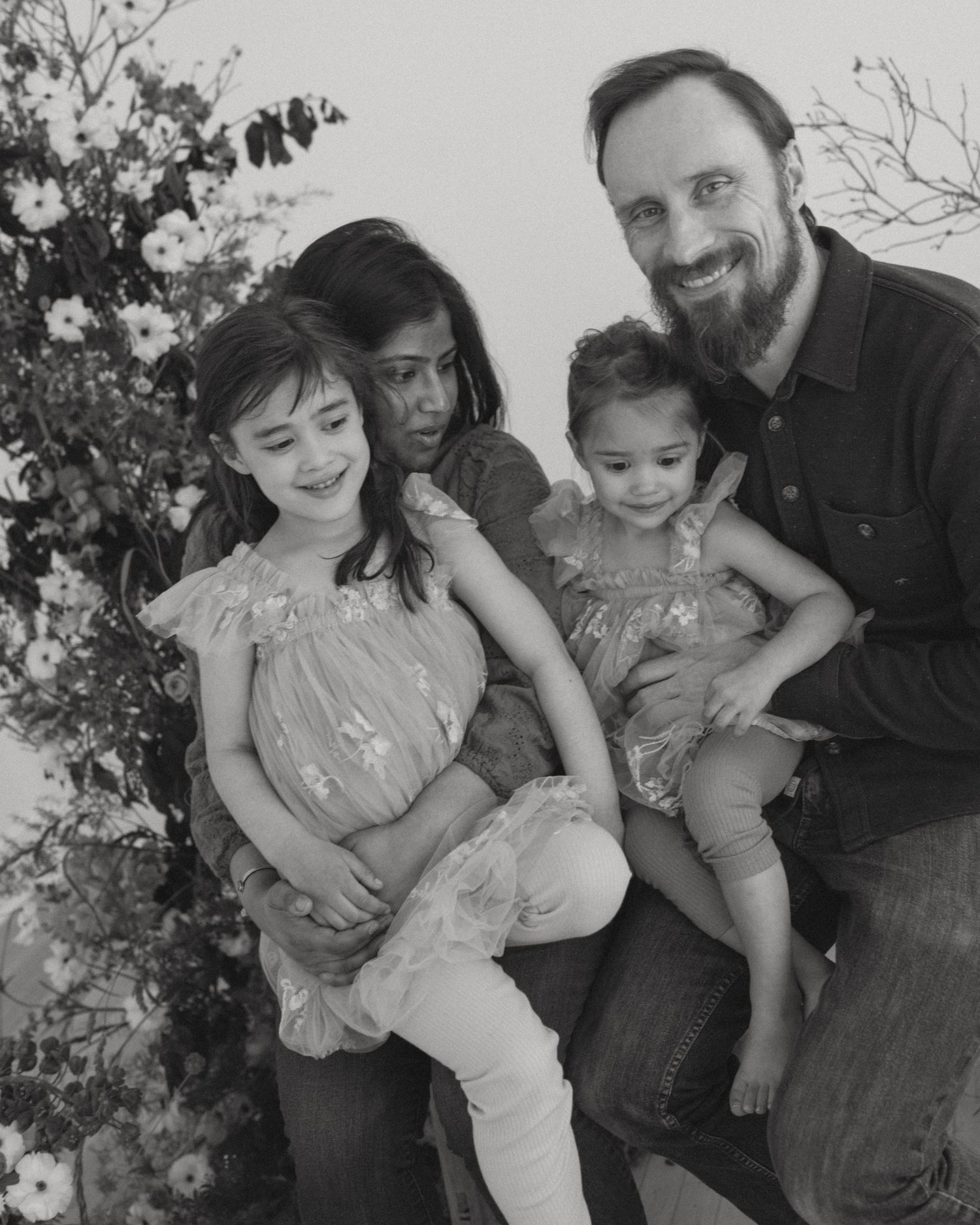A family portrait against a floral backdrop in black and white.
