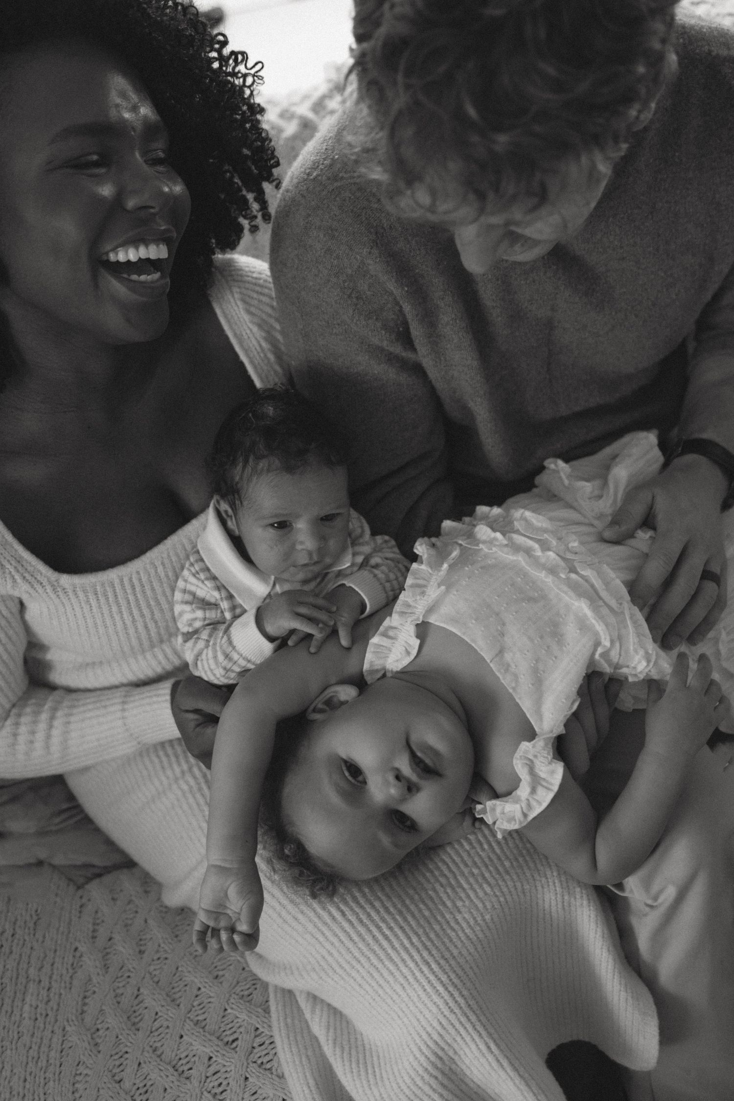 Black and white photo sequence showing intimate moments of family bonding and laughter while lying down together.
