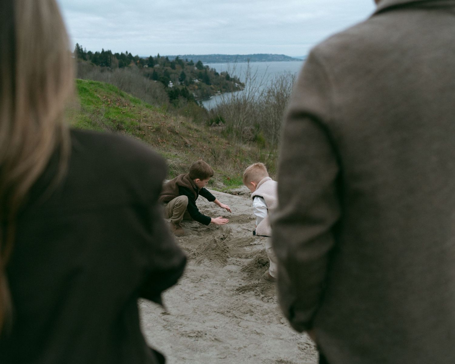 People walking along a scenic coastal trail with water views in the background.