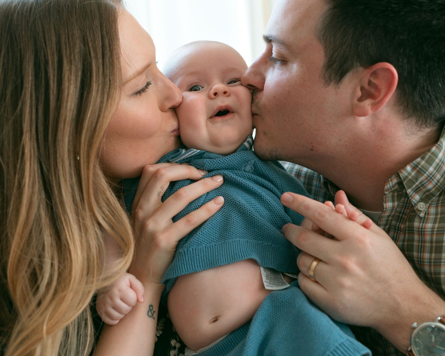 A loving family shares tender kisses and embraces in a series of candid moments captured in warm natural light.