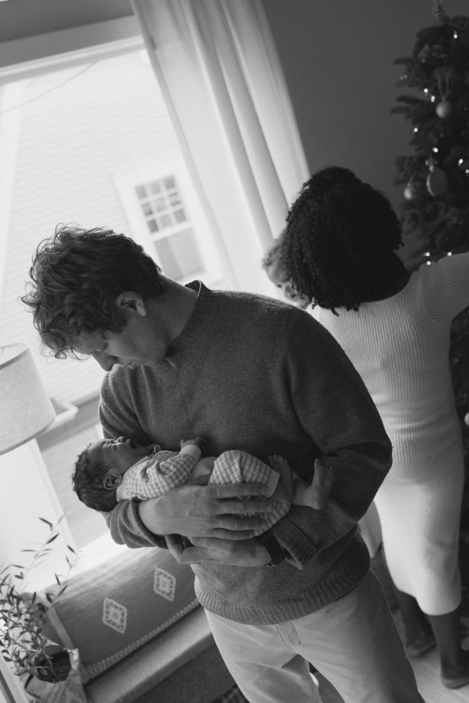 A series of black and white photos showing two people embracing near a window in an intimate moment.