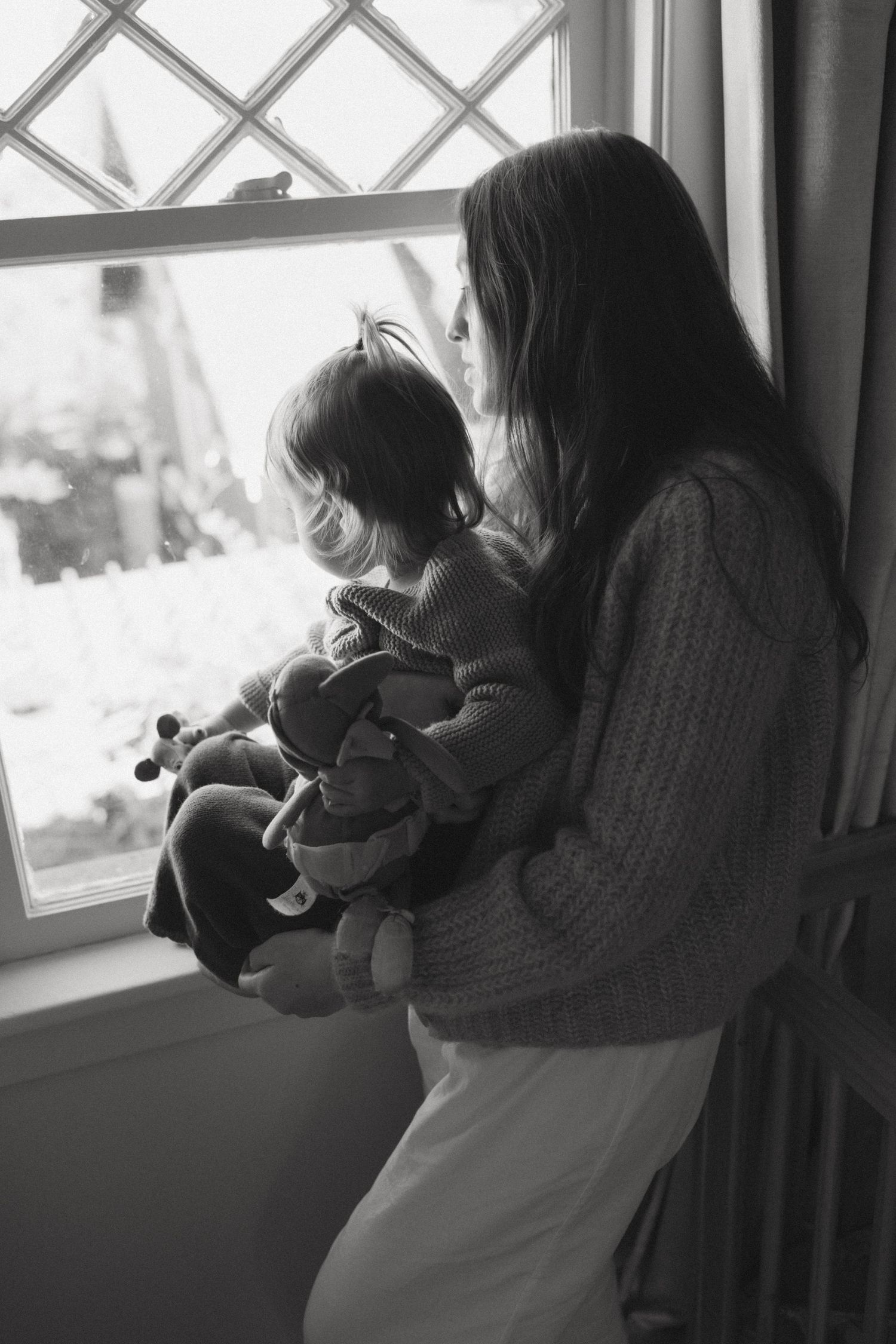 Black and white sequence showing tender moments by a window with lattice pattern.