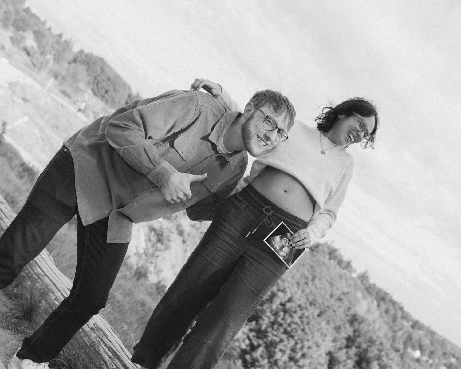 Two people pose playfully near a vintage parking meter.