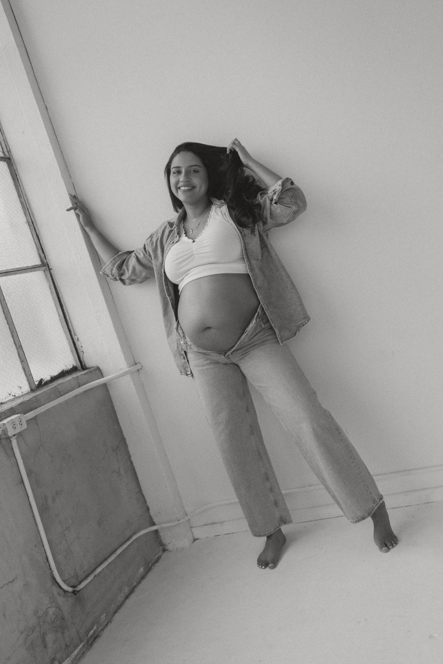 Artistic black and white portraits showing someone posing against a white wall.