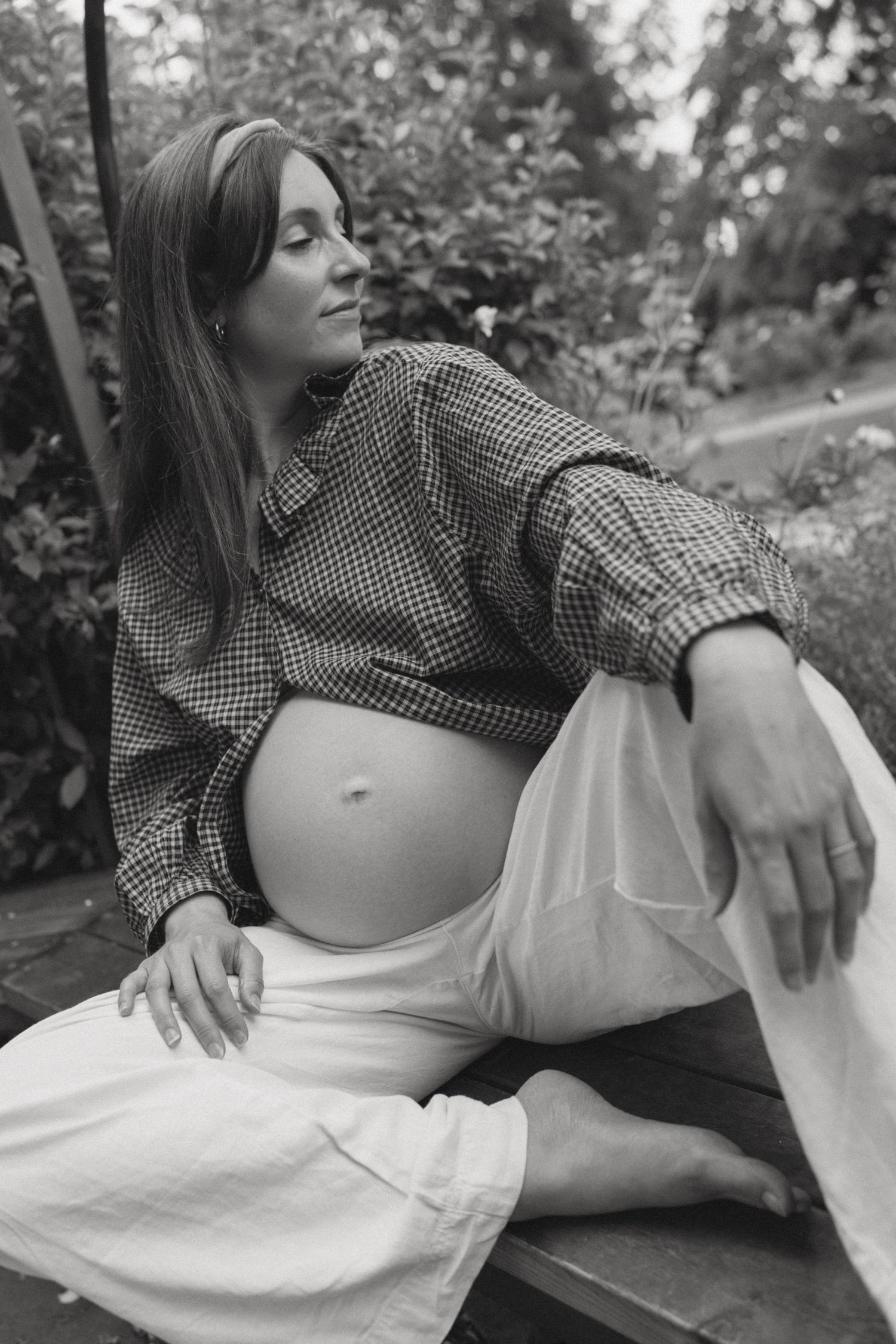 Black and white maternity photos showing expectant mother in casual attire outdoors.