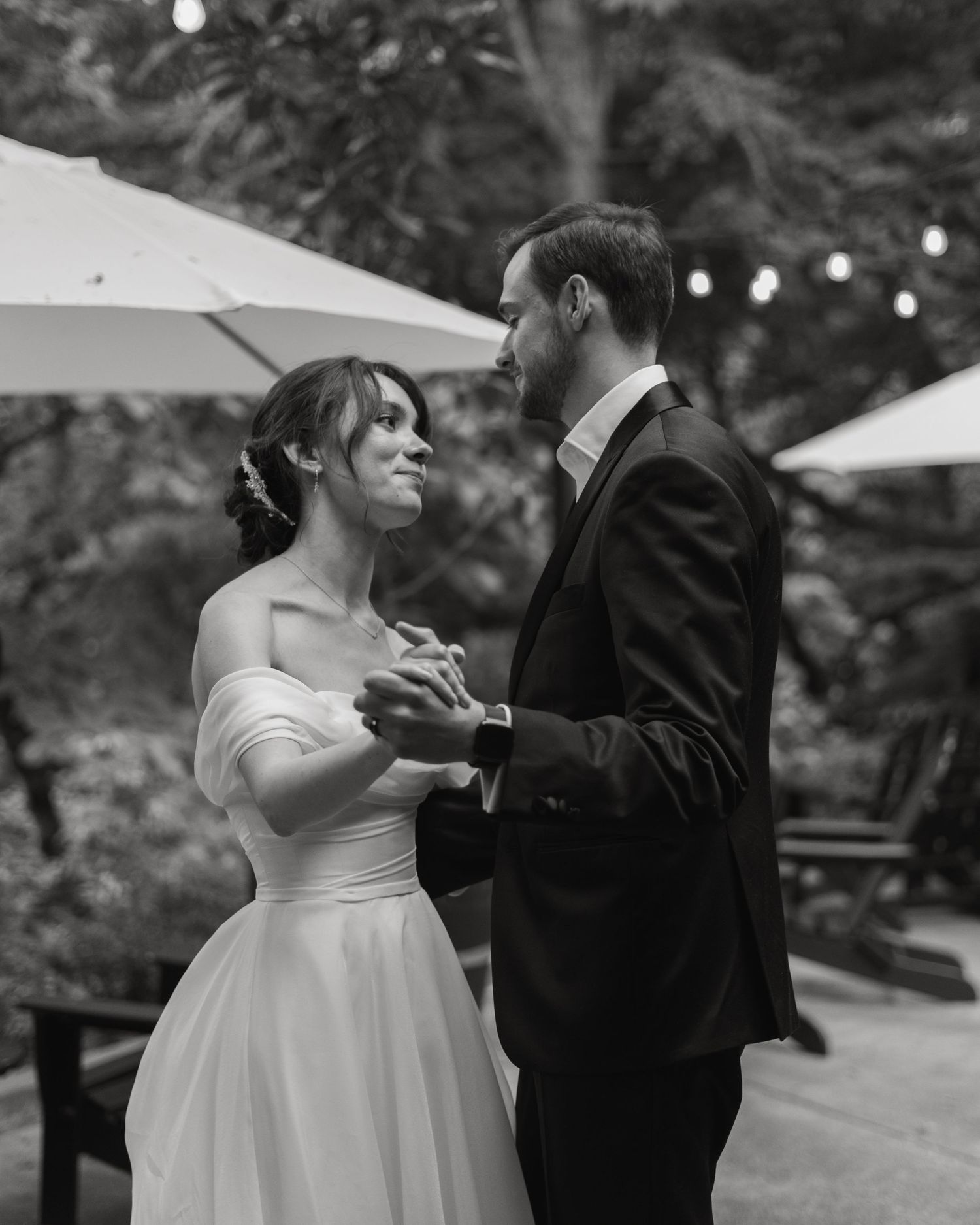 Black and white wedding photos capture intimate moments between newlyweds in an outdoor setting.