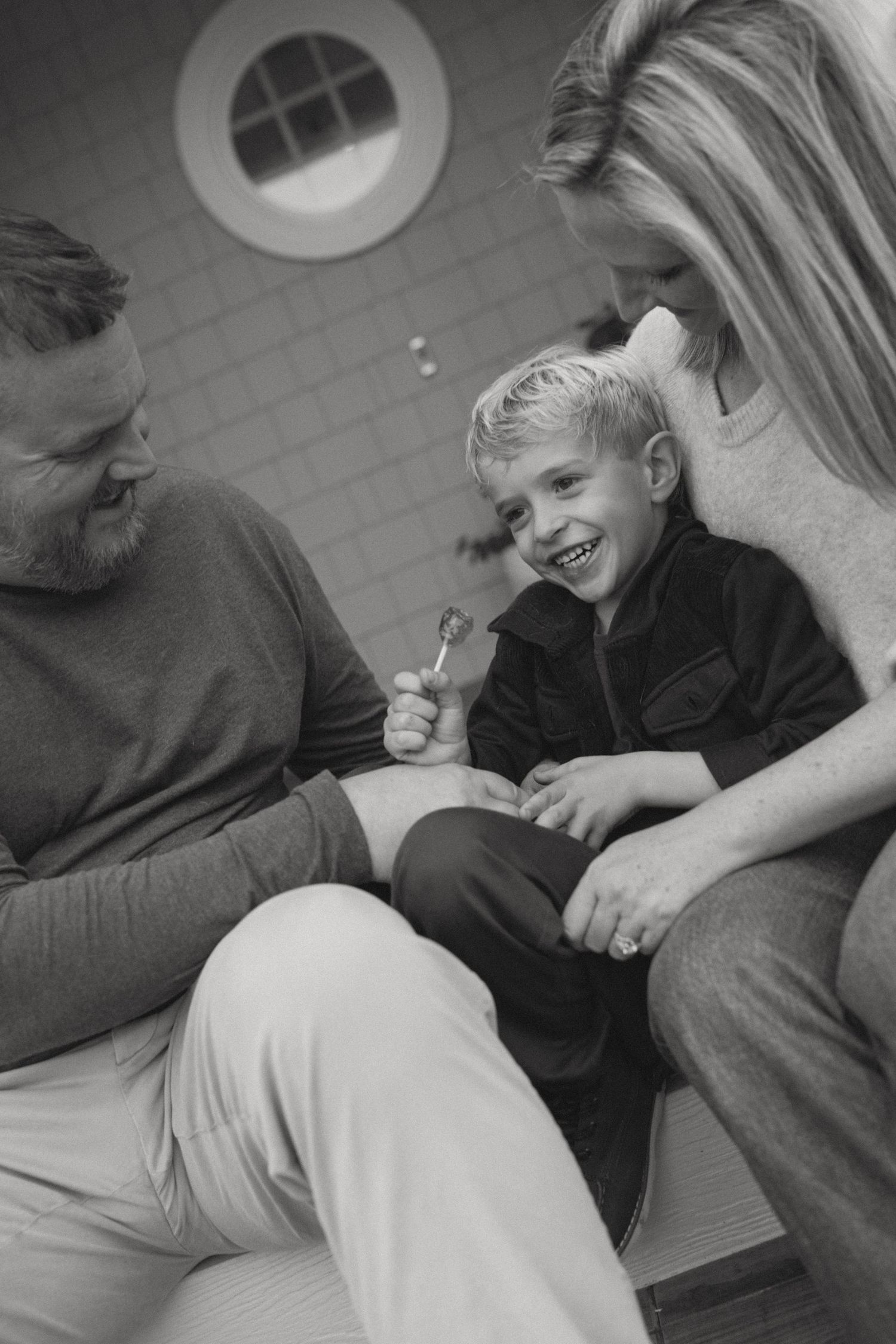 Black and white candid moments of family relaxing together indoors.