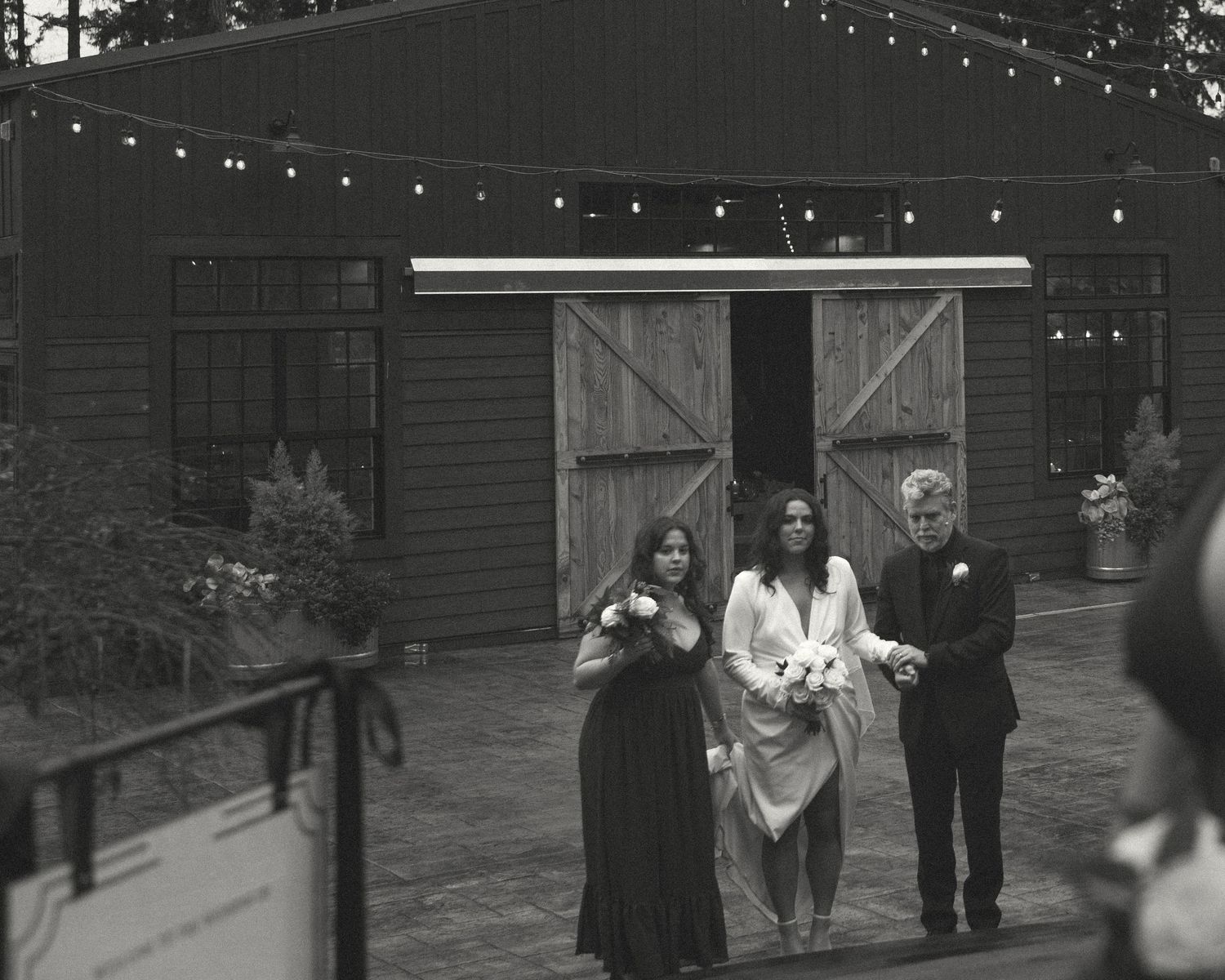String lights create a warm ambiance outside a rustic wooden venue.