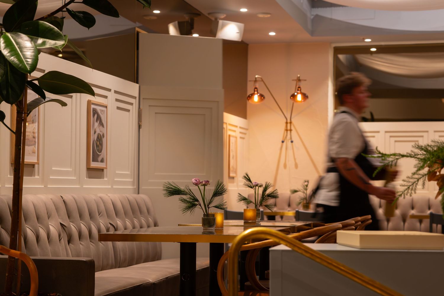 Modern restaurangmiljö med varma lampor och grå sittbås längs väggarna – interiörbild inför event.