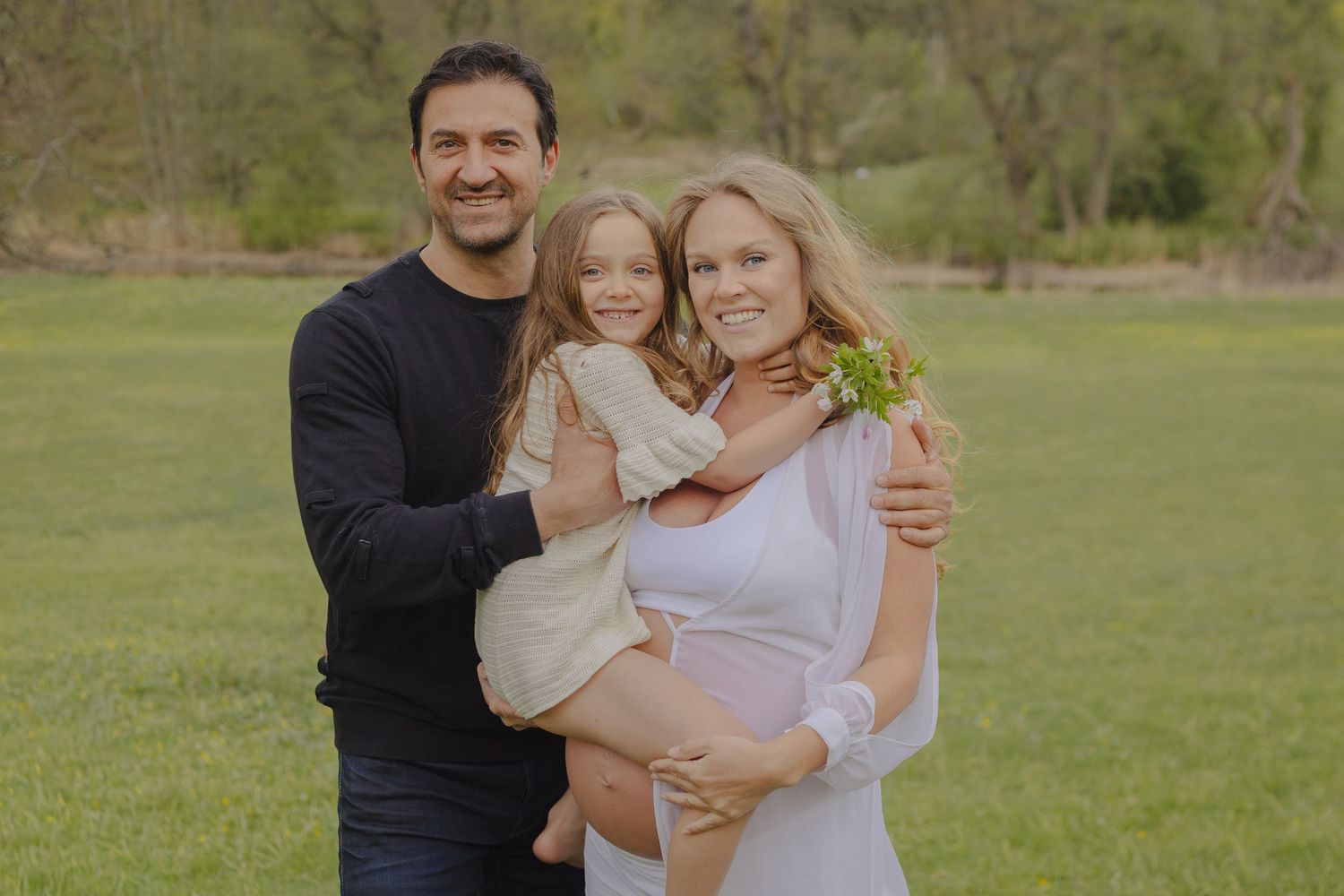 Gravid familj under en varm och naturlig familje- och gravidfotografering i Stockholm.