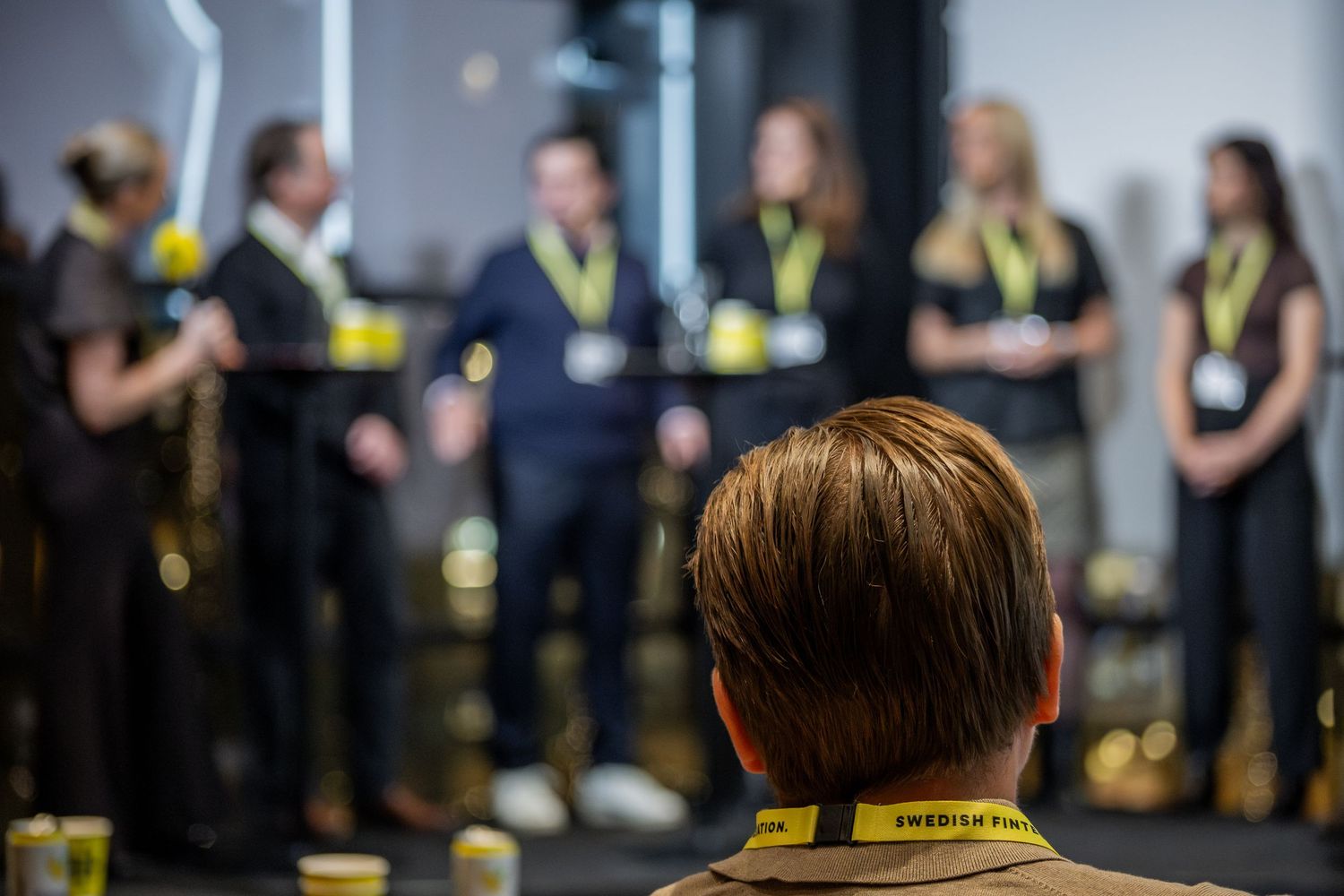 Panel på scen inför publik under företagsevent, eventfotograf dokumenterar prisutdelning.