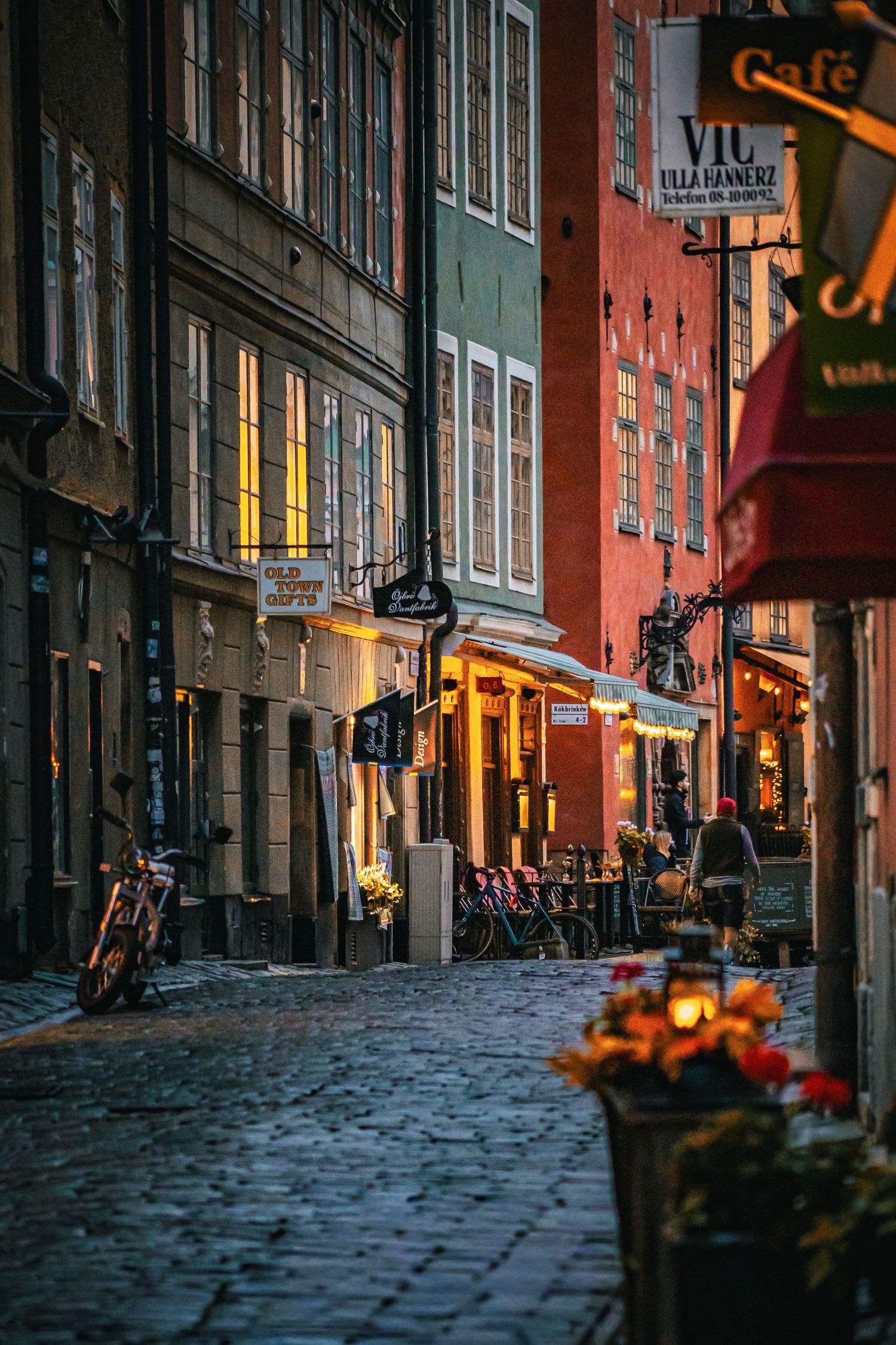 Gamla Stan i Stockholm med kullerstensgata och historiska byggnader i kvällsljus.