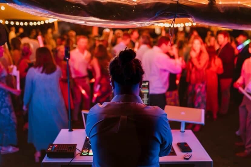 Colorful dance party scene with DJ booth and crowd under red and blue lighting. Rhode Island wedding venues