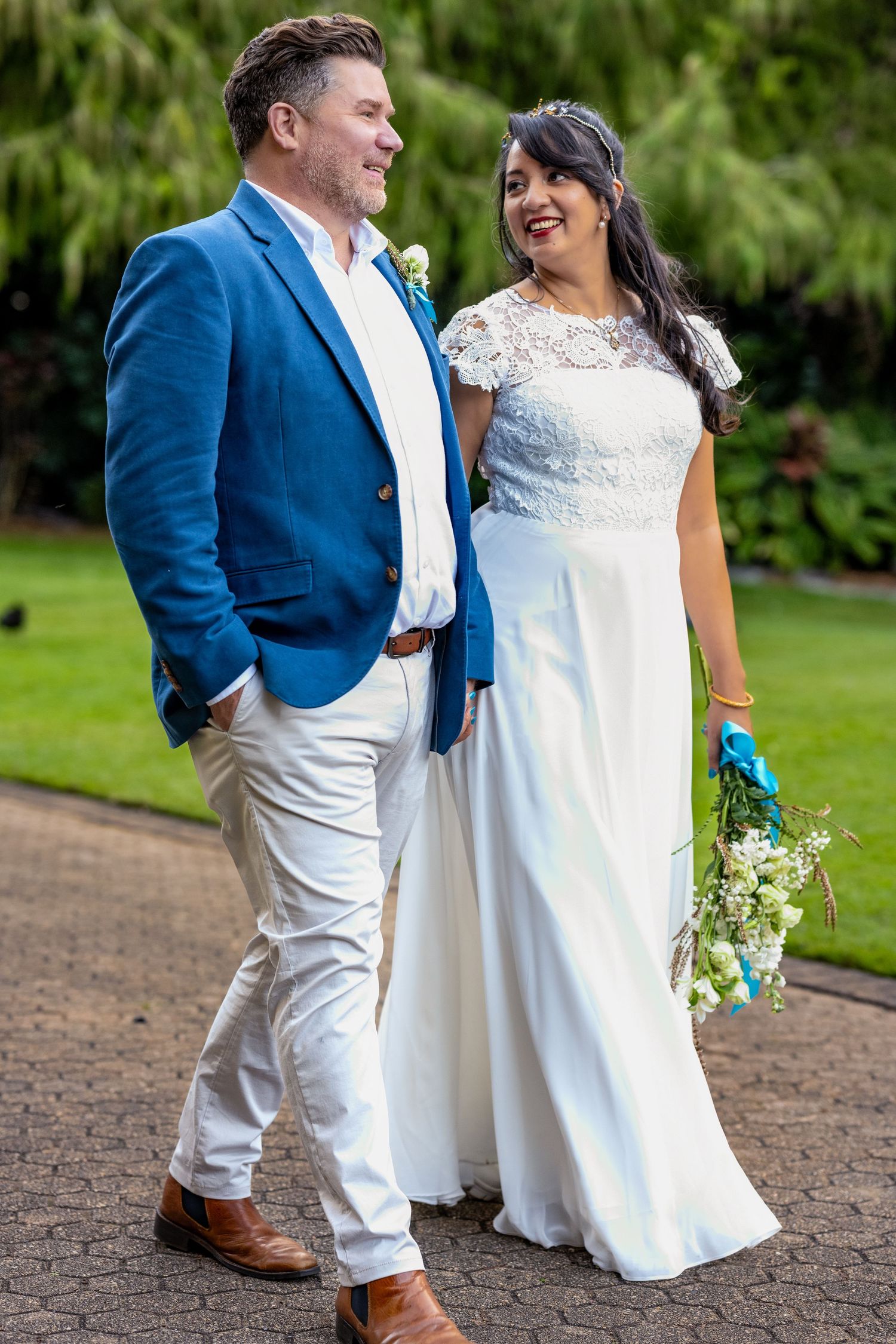 Wedding portraits on a brick path with garden scenery.