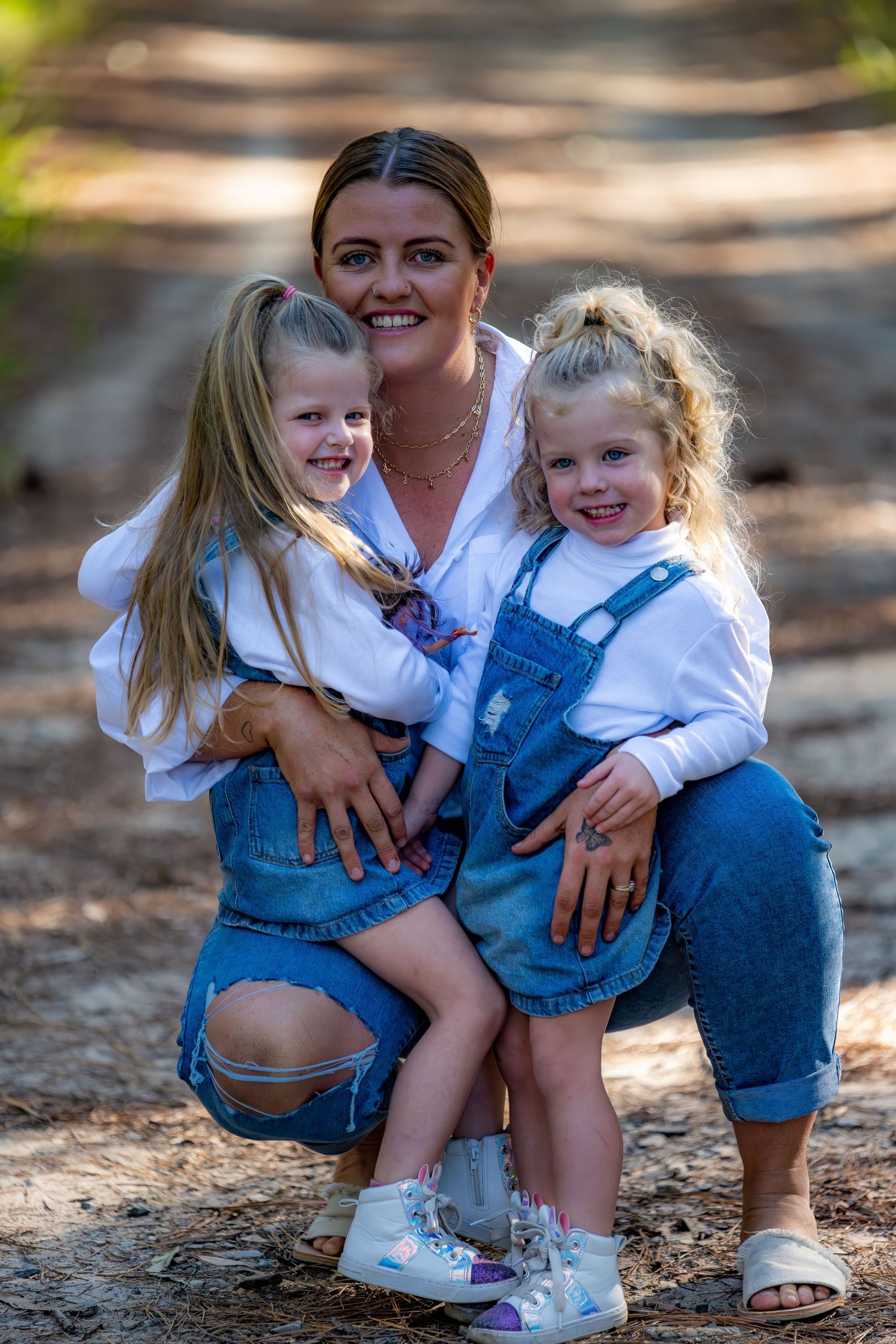 A casual outdoor family moment showing matching denim outfits and bright smiles on a sunny day.