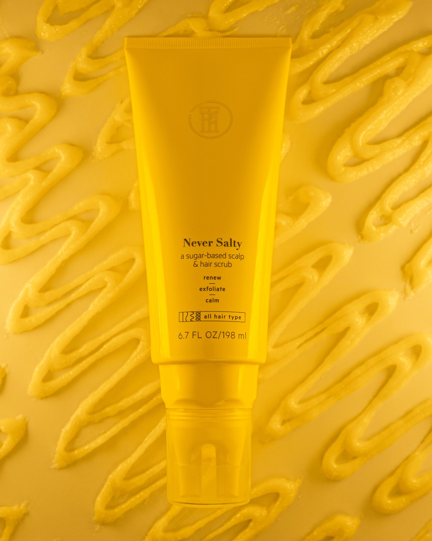 Yellow Never Solo hair product tube photographed against textured wavy background.