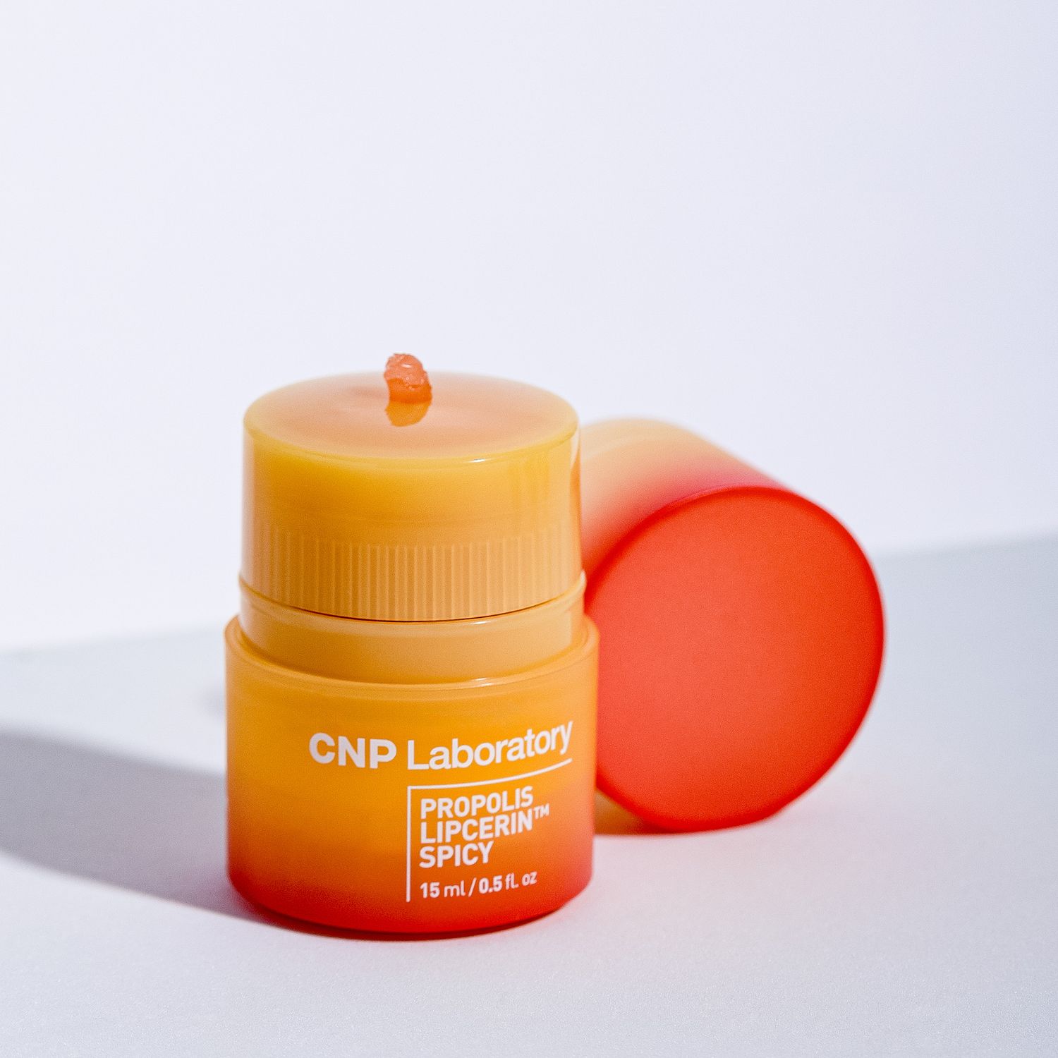 Orange skincare product bottle from CNP Laboratory with Propolis Energy+ label against white background.