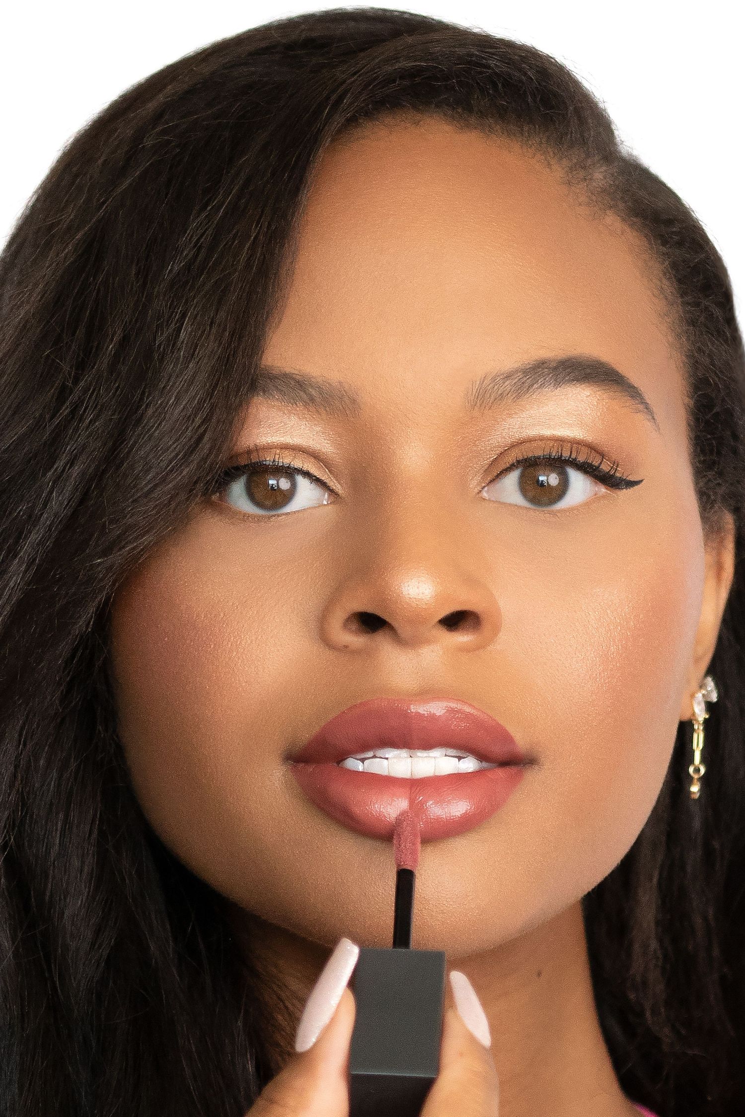 Close-up beauty shot of model applying matte lipstick with precise applicator.