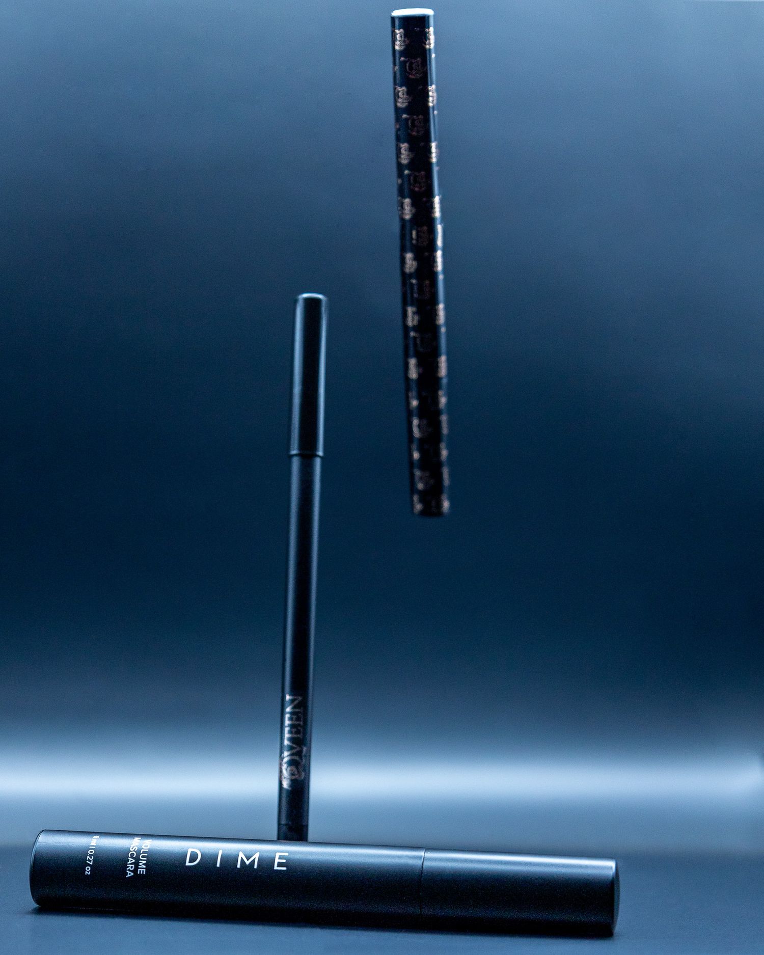 Three black makeup eyeliners arranged vertically against blue gradient background.