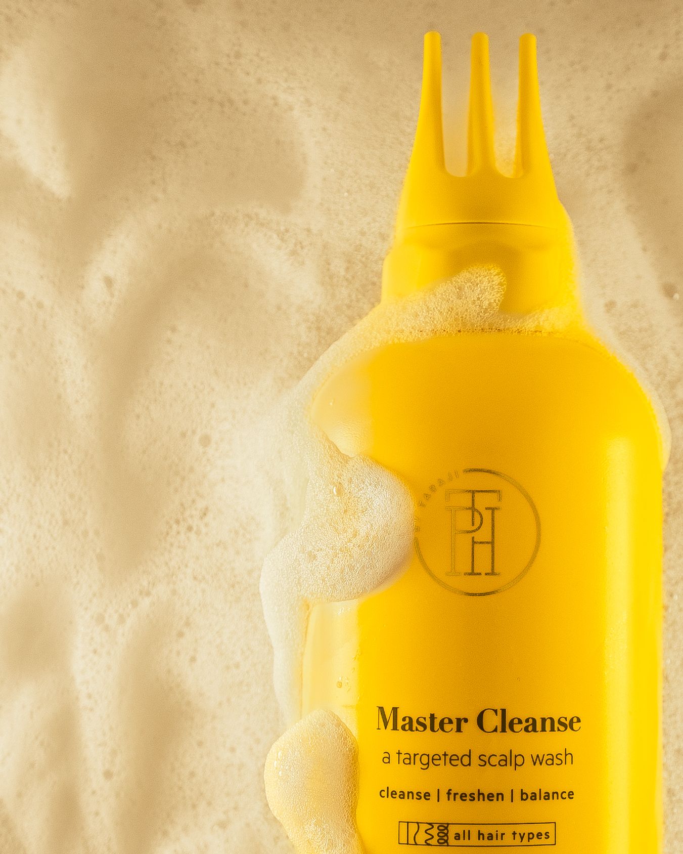 Yellow Master Cleanse bottle with foam bubbles against a textured beige background.