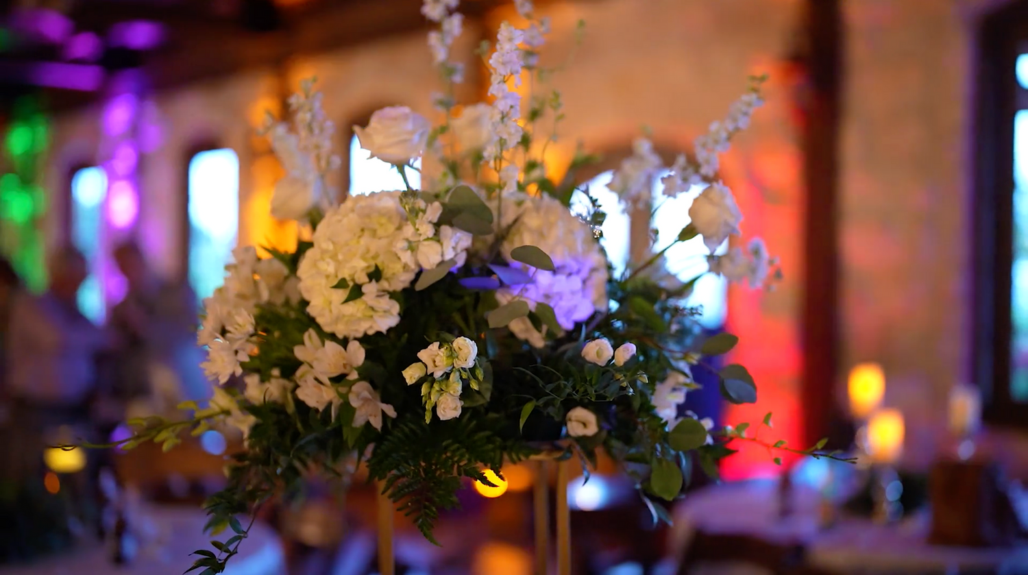 Colorful bokeh lights and white floral decorations create a festive wedding reception atmosphere.