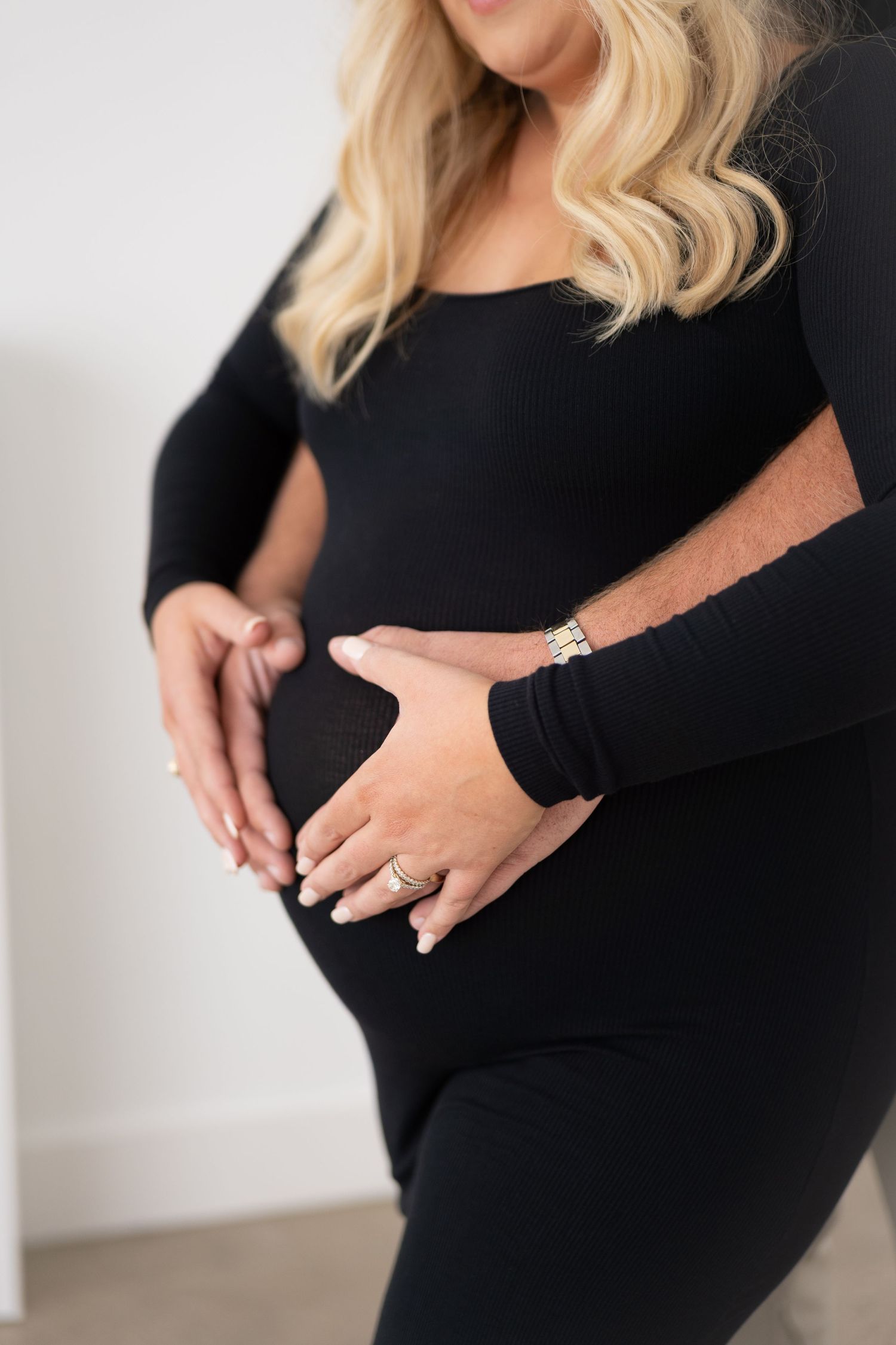 Woman in black dress showing pregnancy progression through multiple photos.