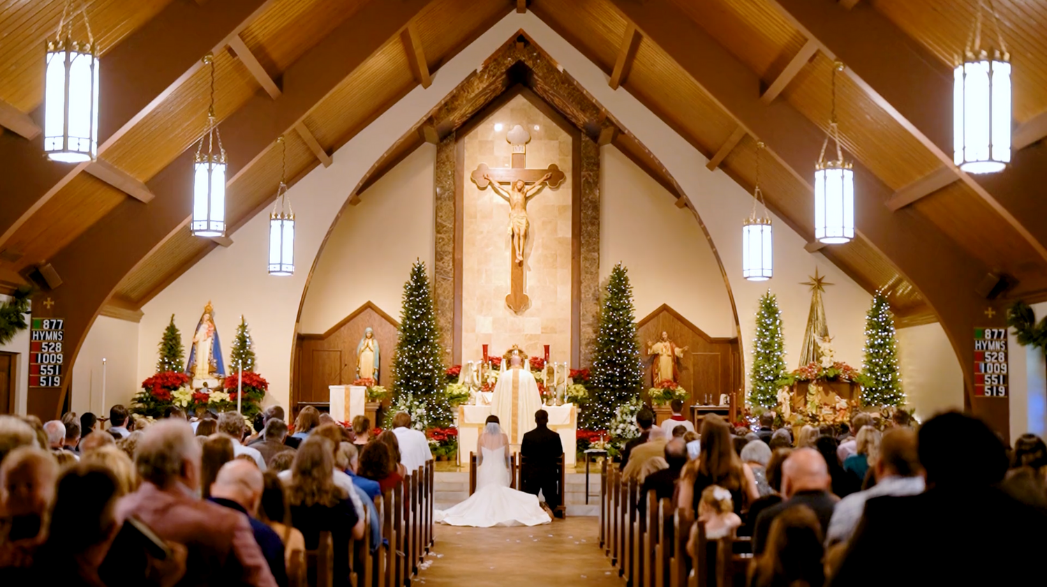 Interior of a church sanctuary with vaulted ceiling and hanging pendant lights for a wedding ceremony.