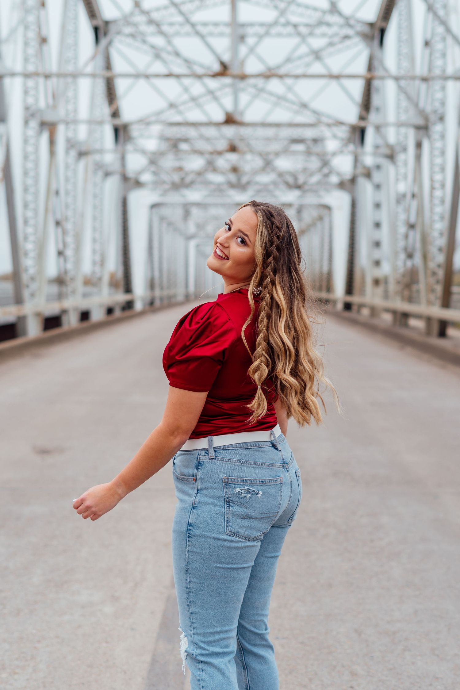 Dynamic movement shots on metal bridge wearing casual red top and denim outfit.