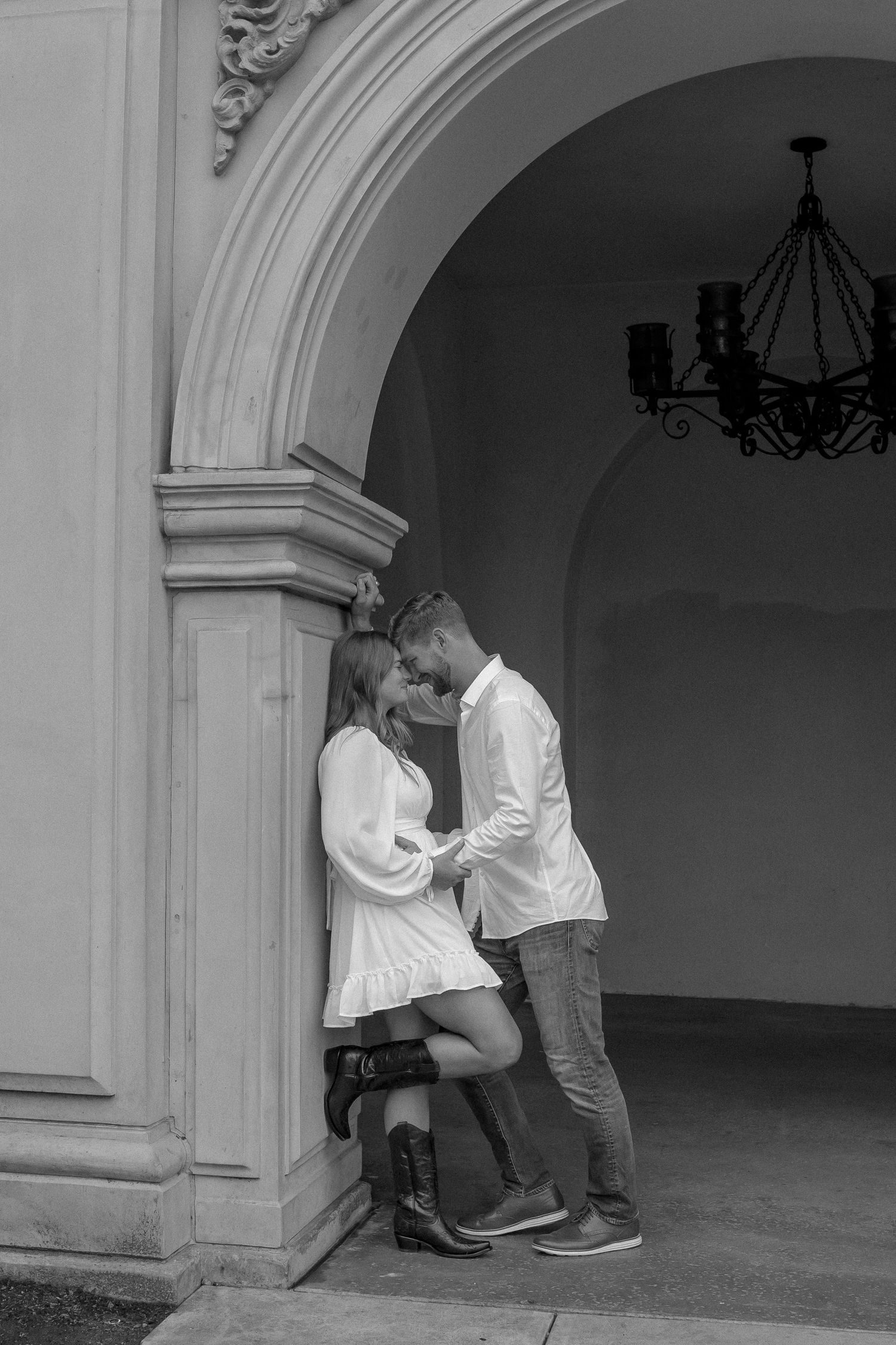 A romantic black and white series of photos capturing an intimate moment under an archway.