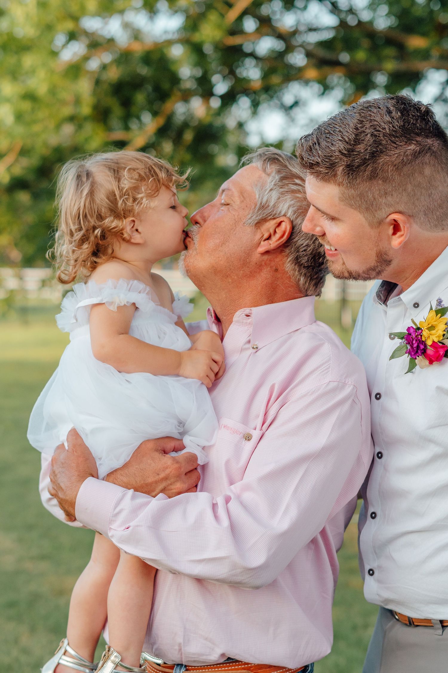 Sweet moment during a wedding celebration as people embrace in a garden setting.