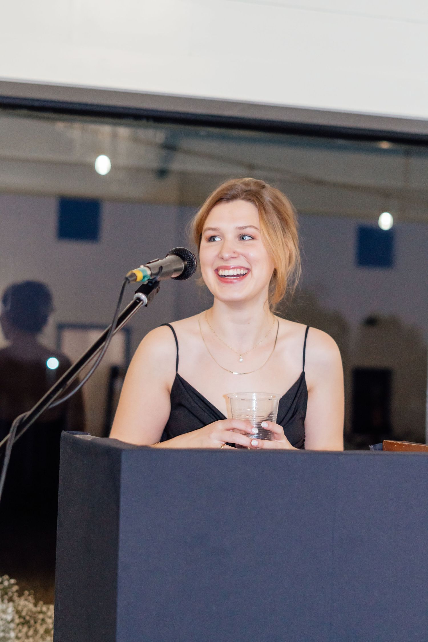 Person speaking at a podium during an indoor event.