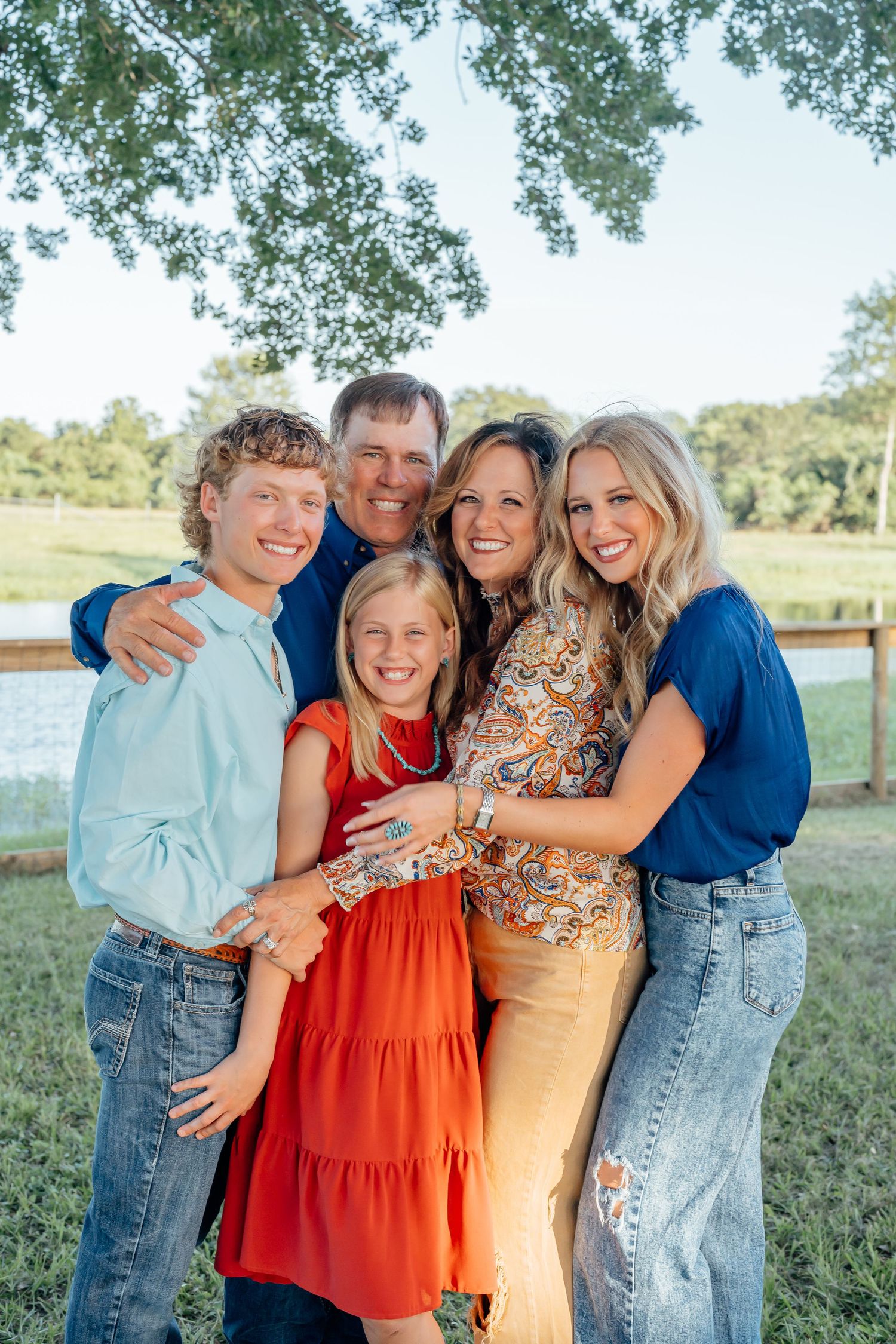 Casual outdoor family photos with coordinated blue and orange outfits in a natural setting.