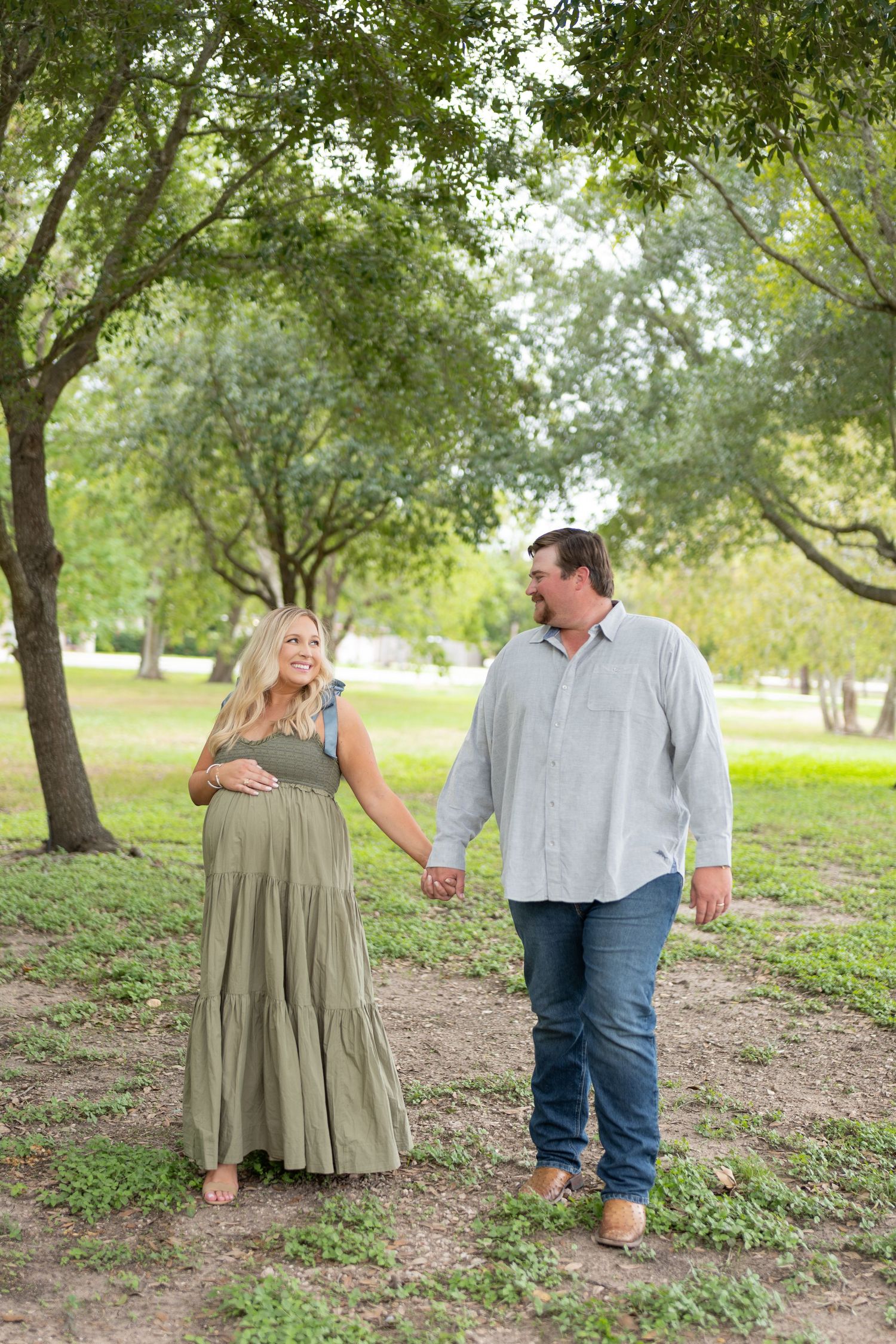 Romantic couple photo series in a park setting with trees and natural lighting.