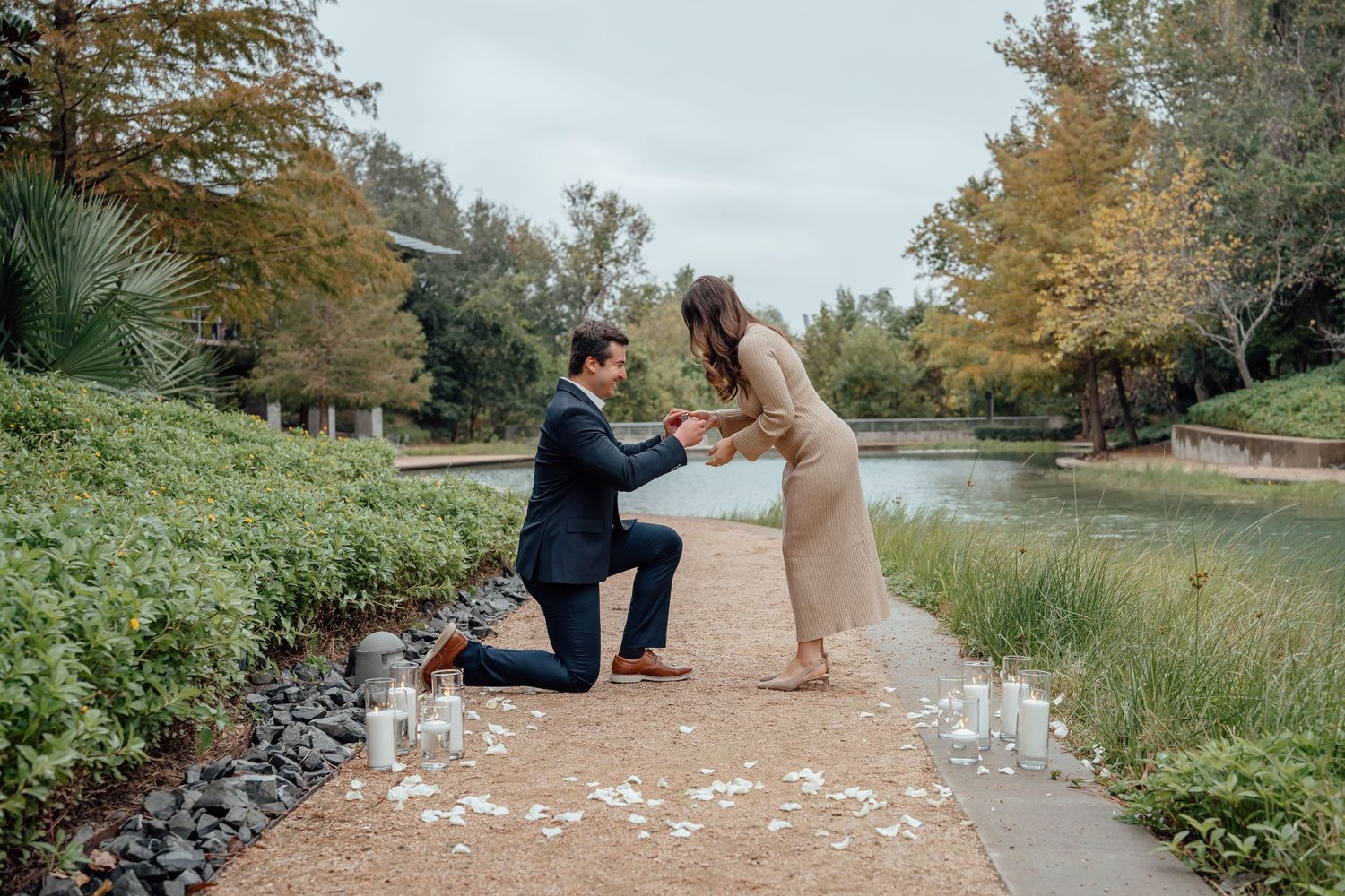 A romantic proposal scene unfolds on a scenic outdoor path surrounded by nature.