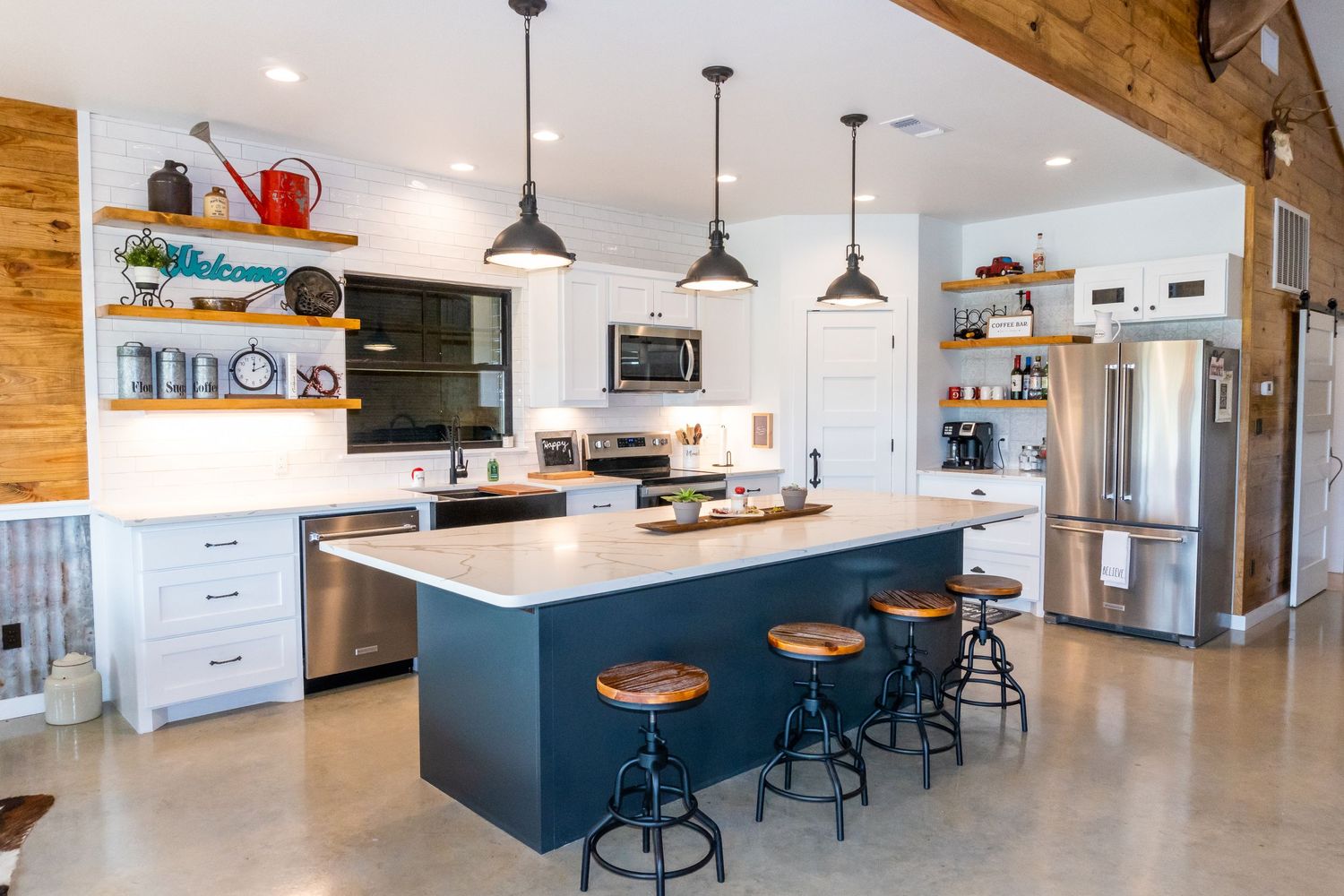 Modern blue and white kitchen with pendant lights and bar seating.