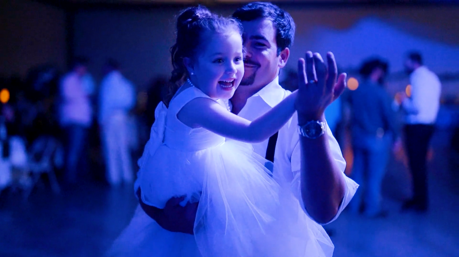 Wedding reception dance floor illuminated with blue lighting effects.
