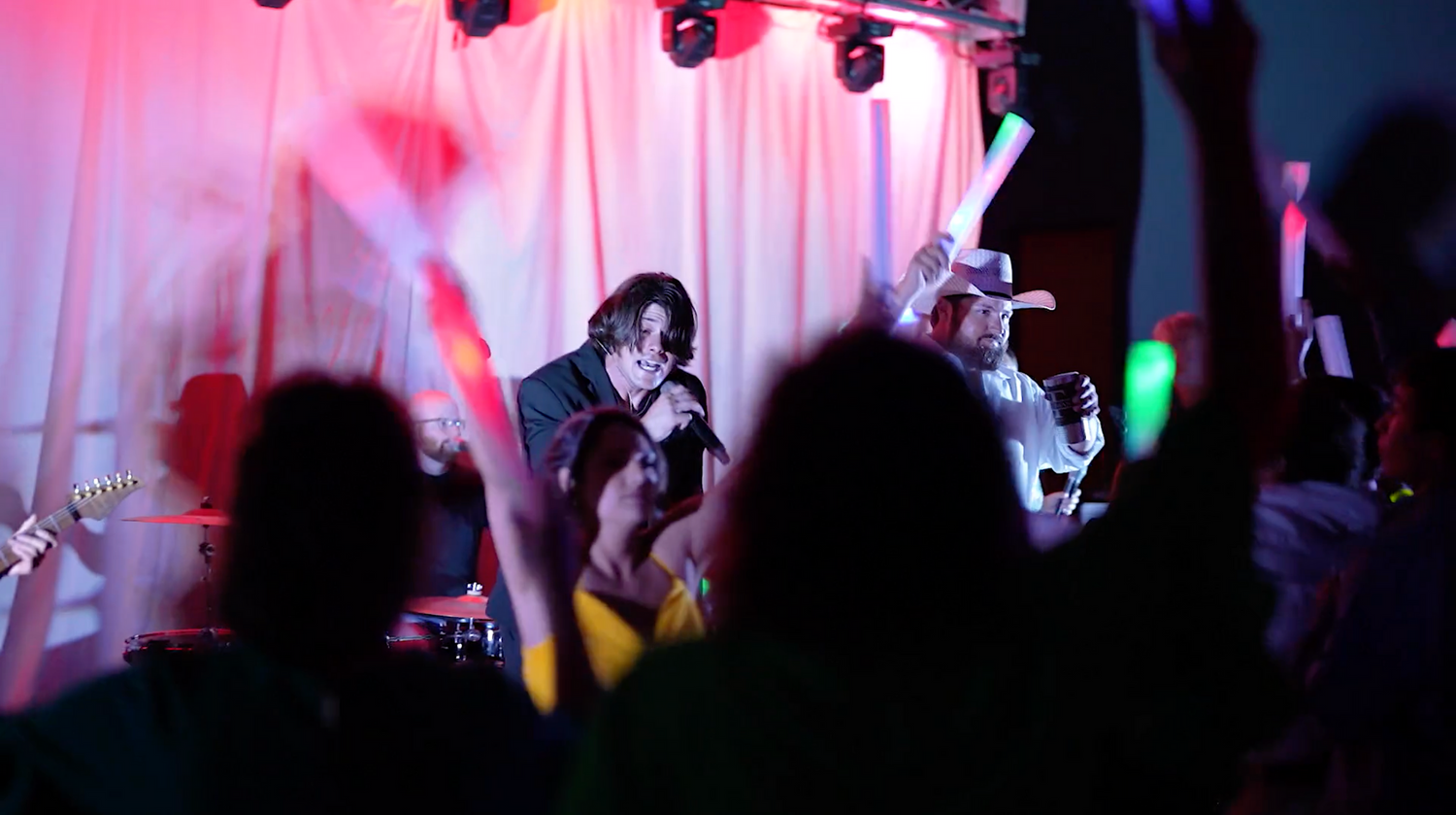 Concert-style lighting setup with silhouettes creates atmosphere at wedding reception.