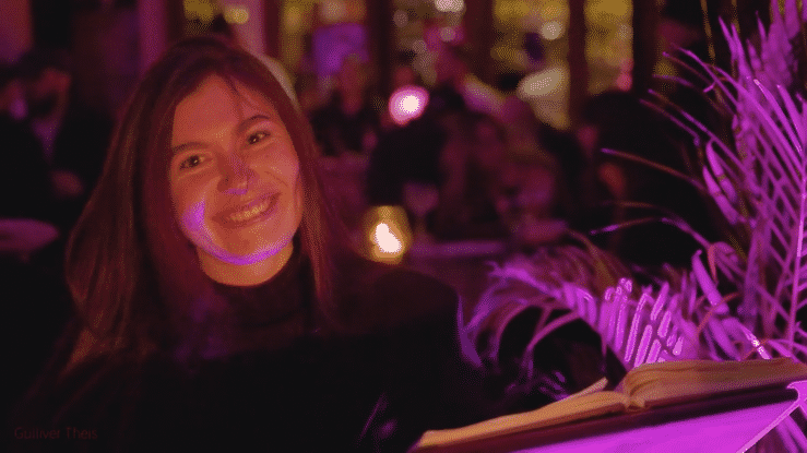 People dancing and having fun at a nightclub with purple lighting and disco atmosphere.