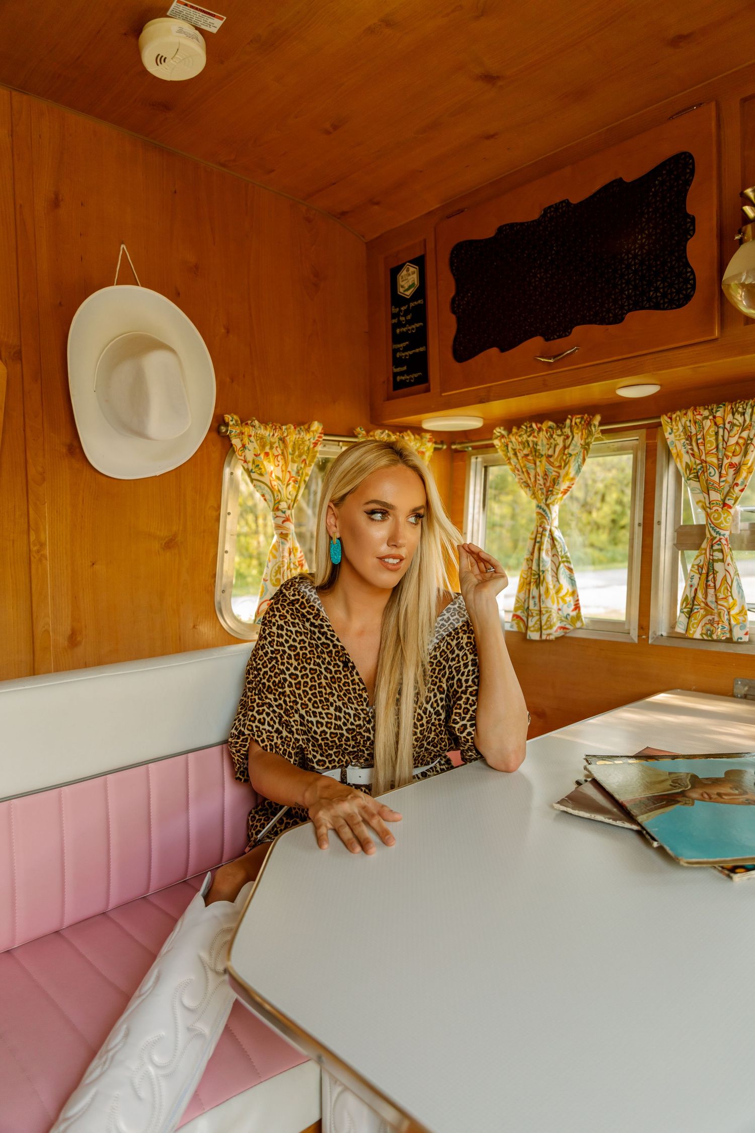 Interior shots of vintage camper with wood paneling and pink booth seating for Tracie Lynn, nashville country artist.