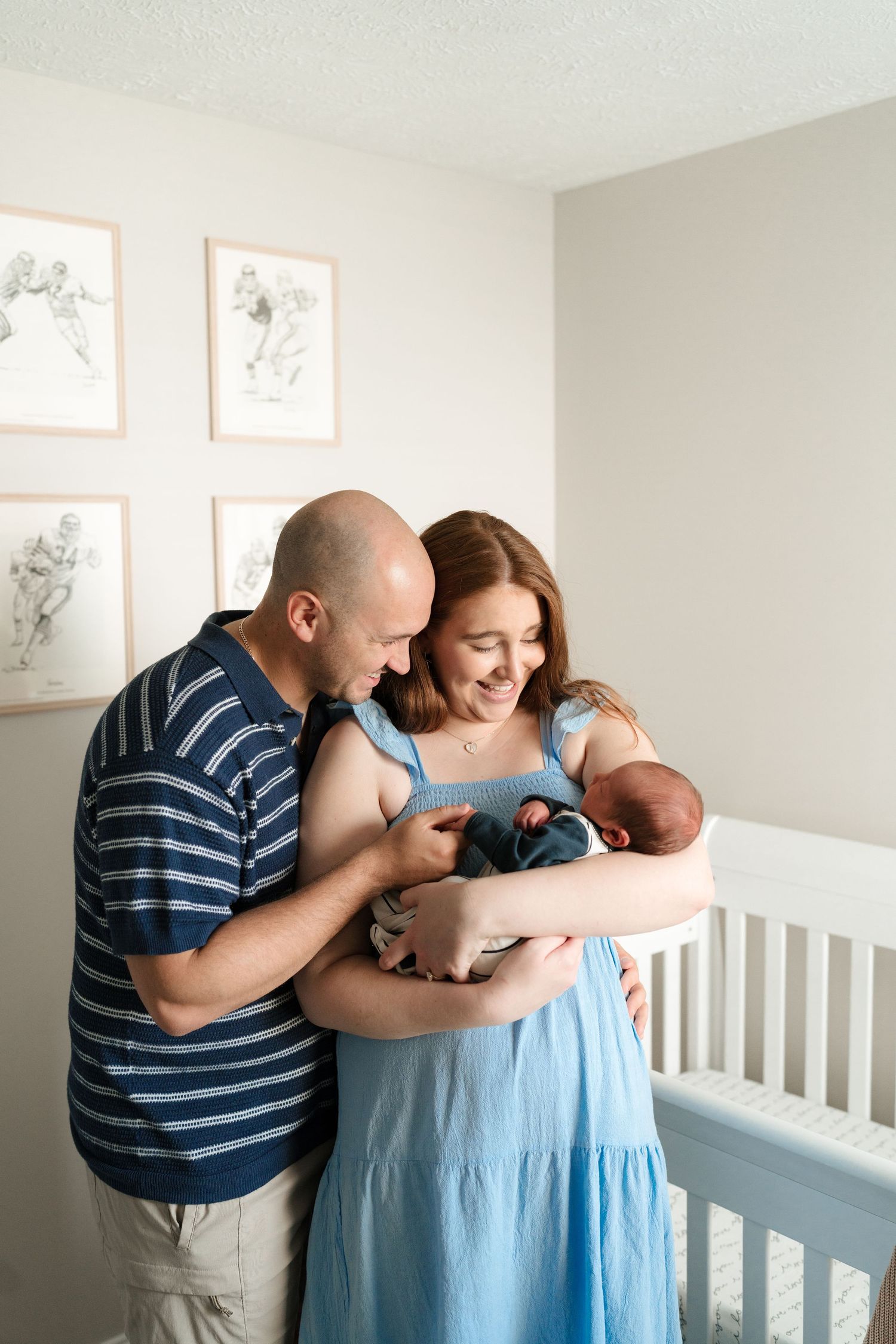 Tender family moment with newborn baby fresh 48 photoshoot in nursery with white crib.