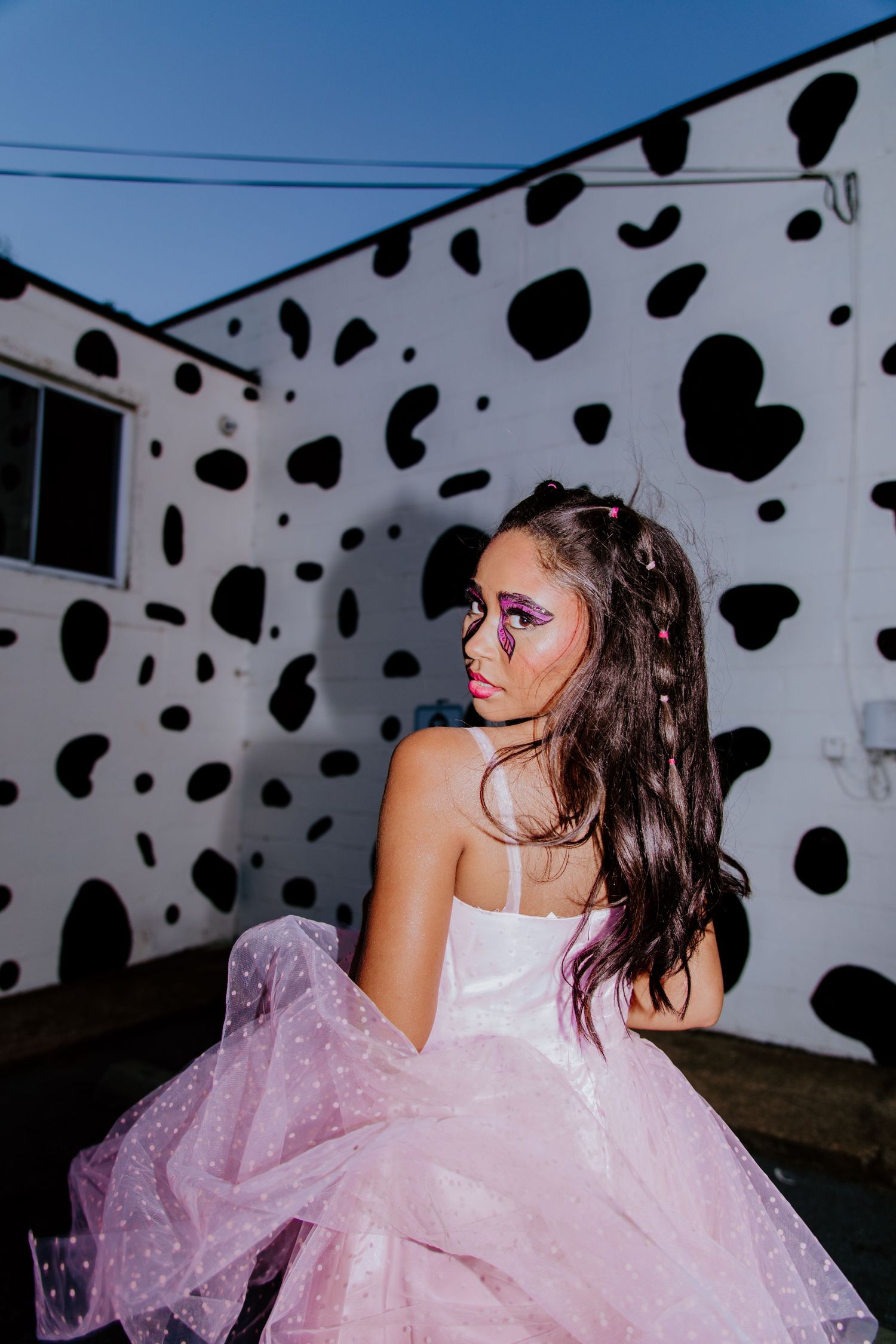 Fashion shoot against polka dot wall featuring pink tulle dress in East Nashville photoshoot with model Elise Stein.
