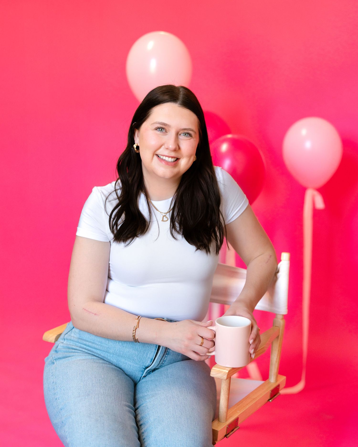 Branding session against vibrant pink background with balloons.