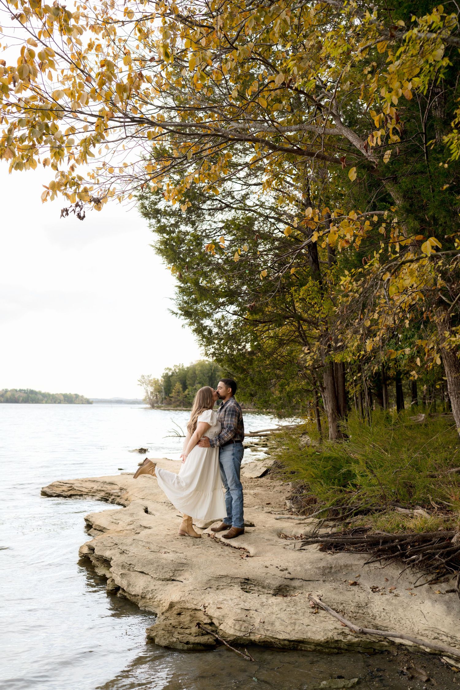 Romantic engagement session by the water with autumn trees in Nashville TN.