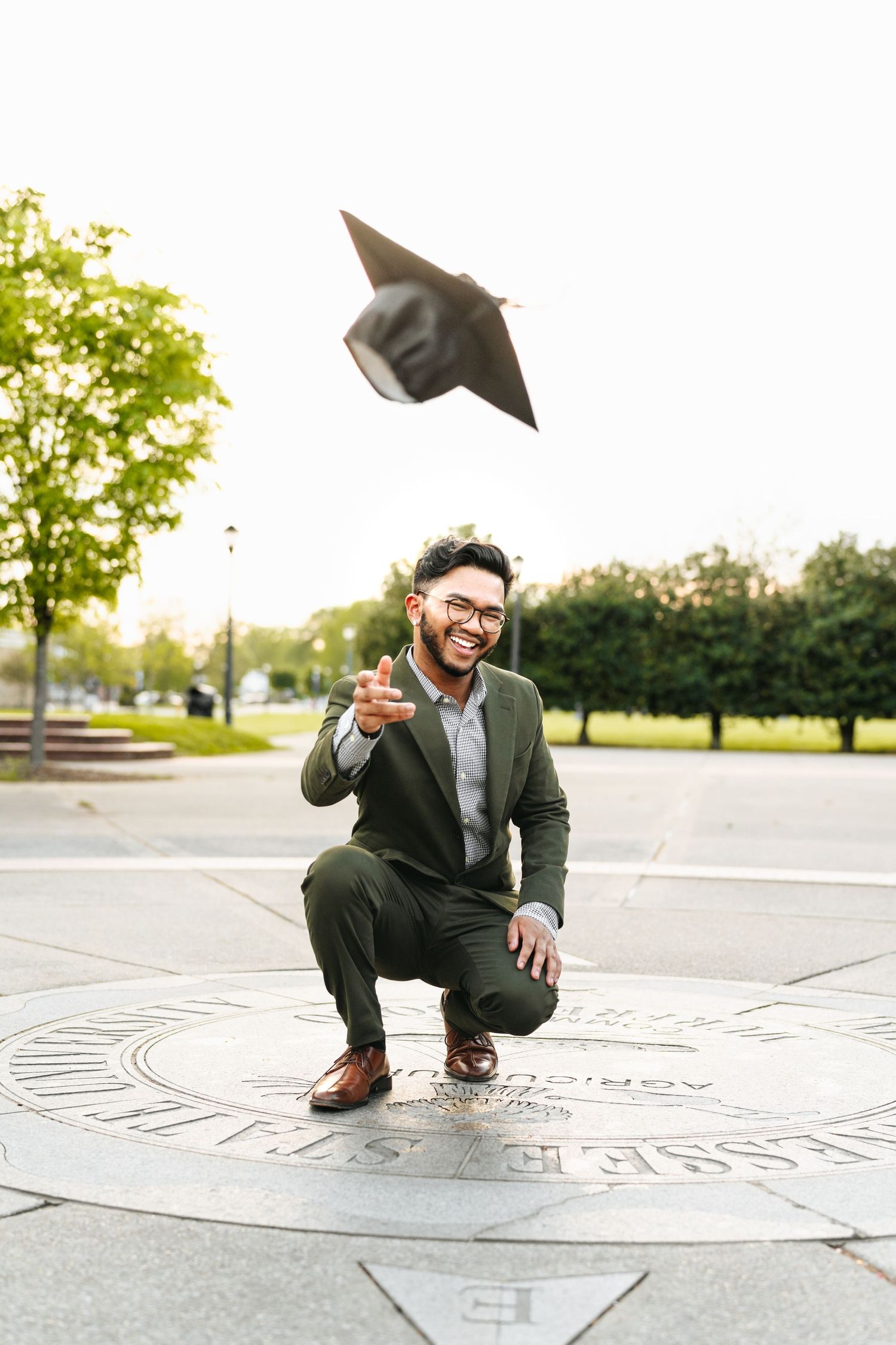 MTSU Graduate tossing cap in celebration on university seal in murfreesboro tn
