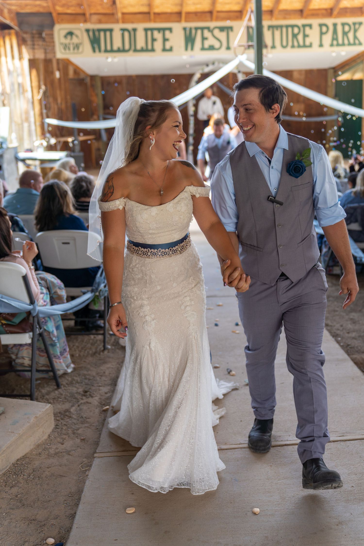 A couple in wedding attire dancing together on a rustic wooden floor during their celebration.