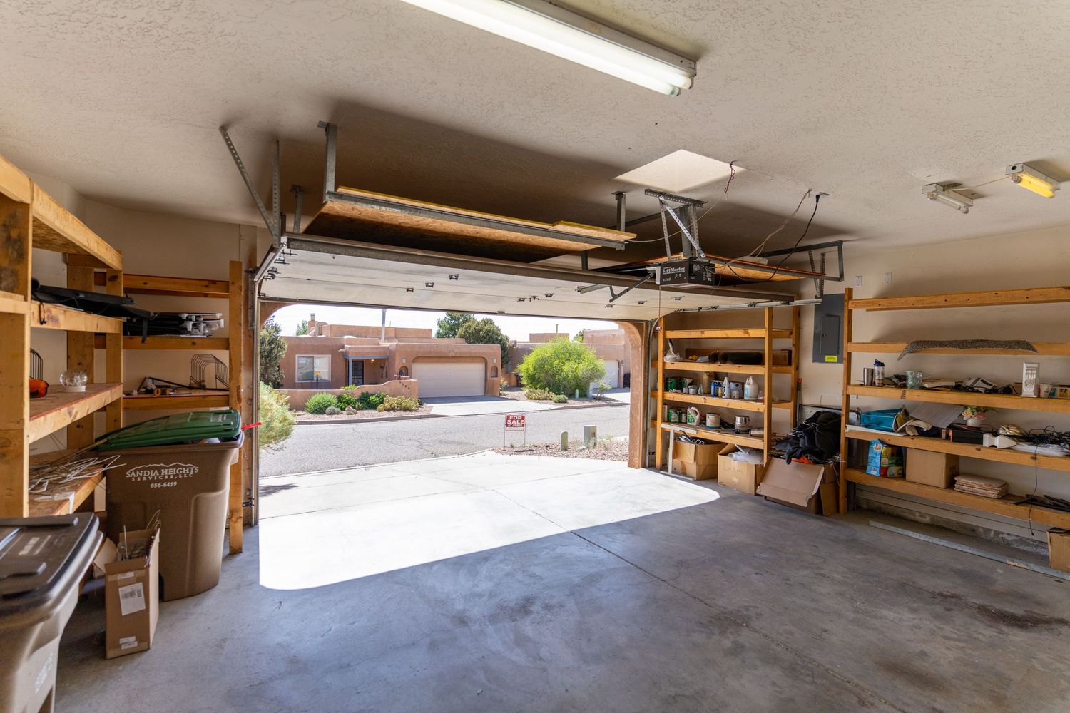 A long panoramic view of a storage area with wooden shelves and equipment in a well-lit indoor space.