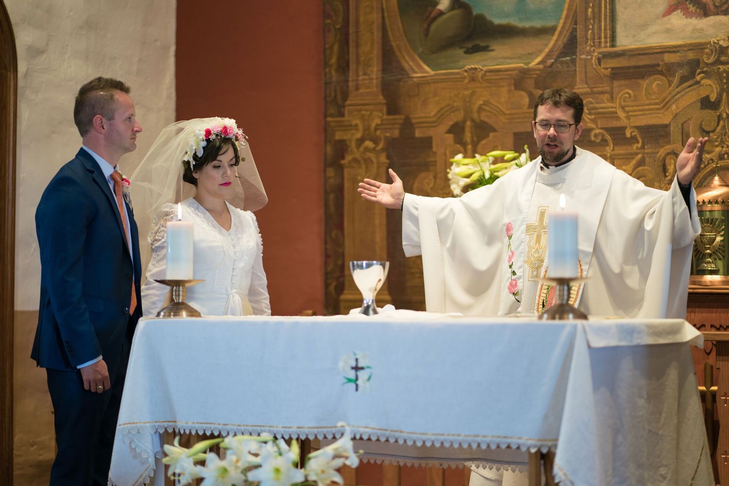 Catholic priests and clergy members gather at an altar during a religious ceremony in a church.